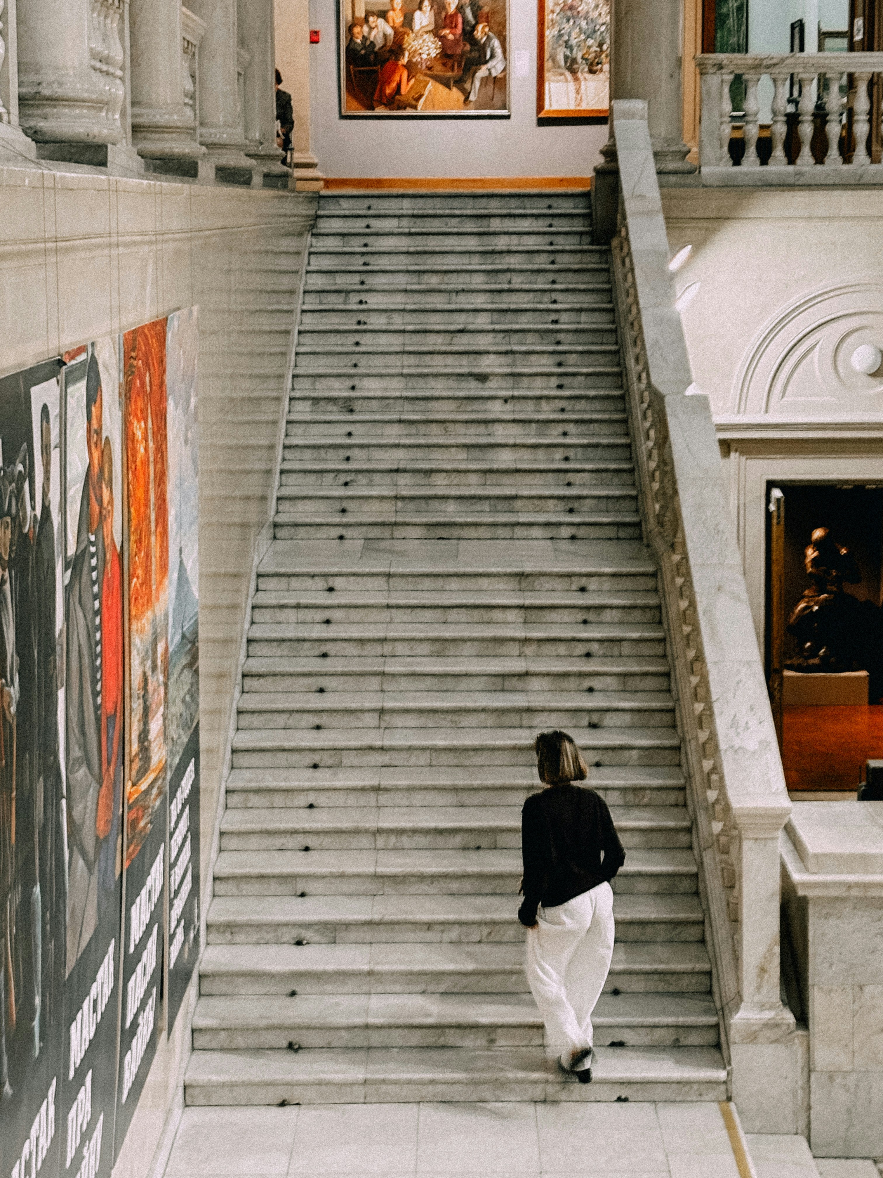 A person walks up stairs in a museum.