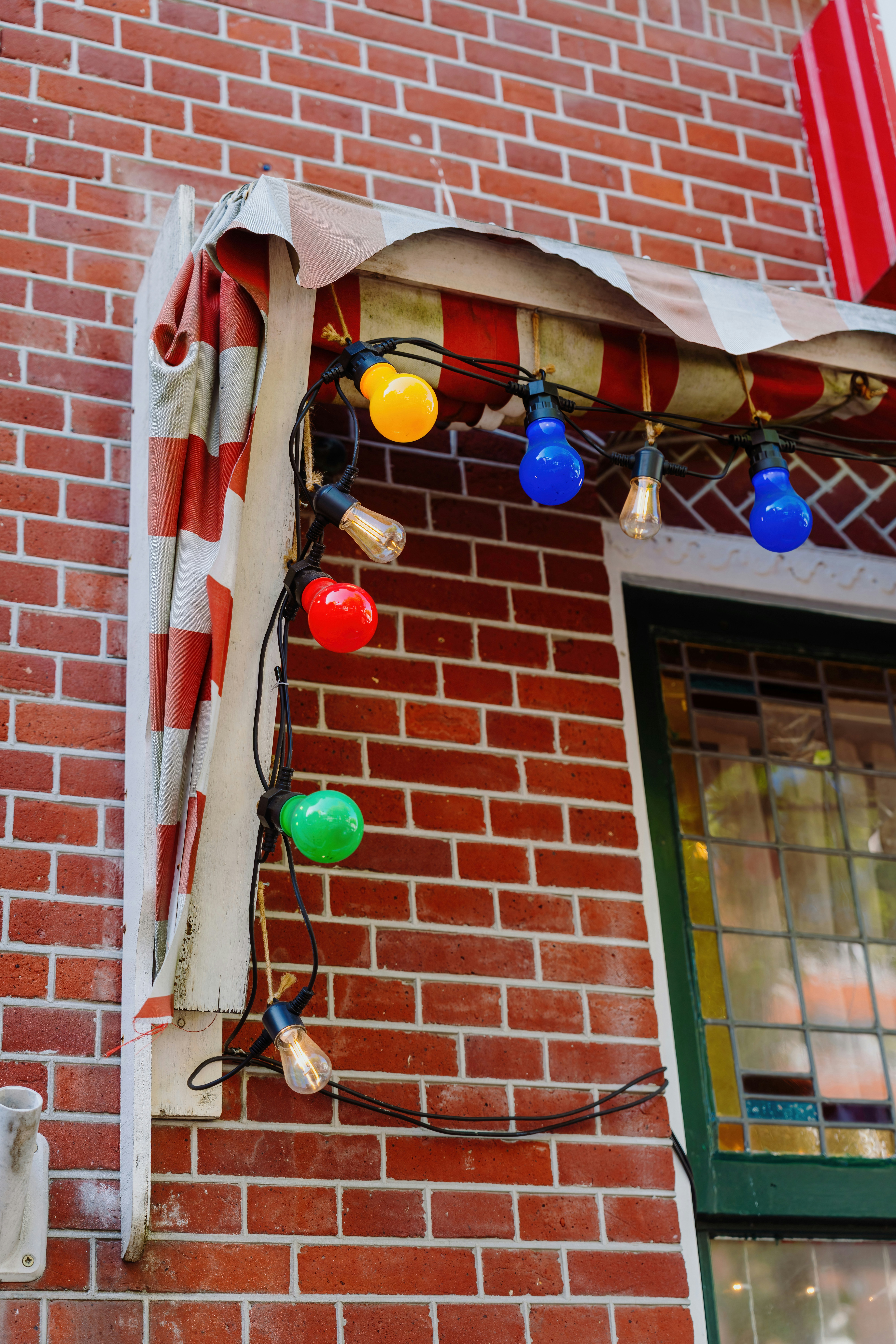 Colorful string lights adorn a brick building.