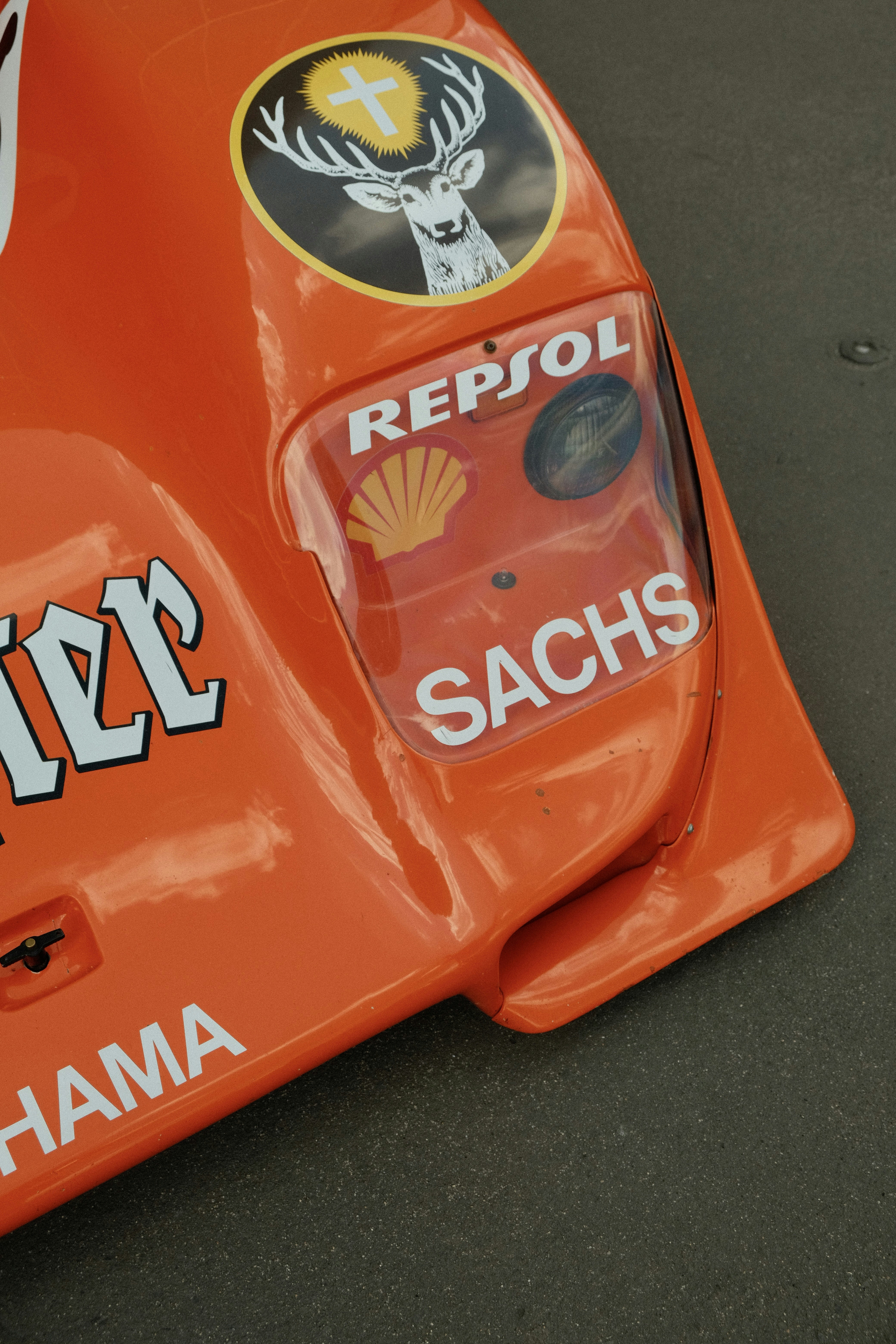 Orange race car details with various sponsor logos.