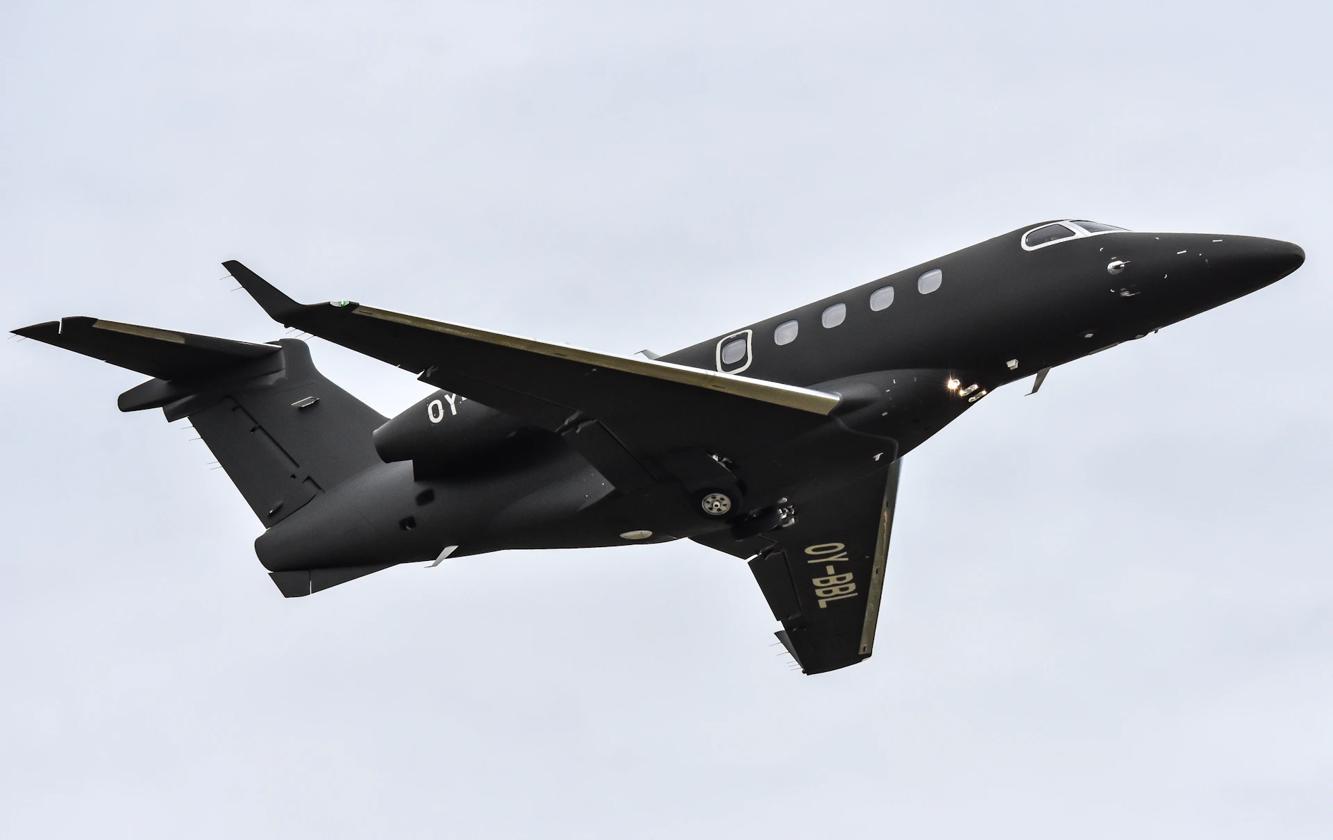 A black jet airplane is soaring through the sky.