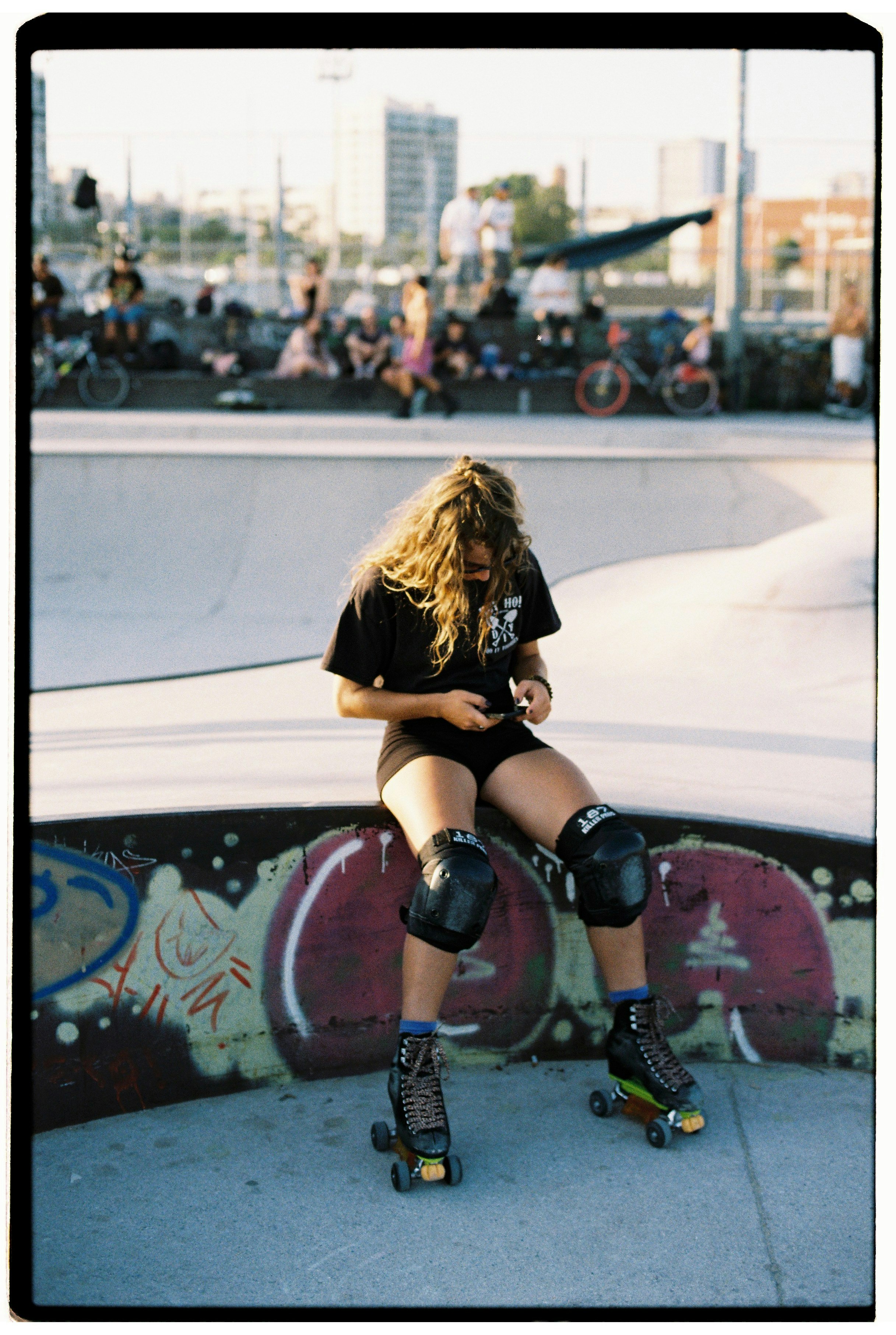 A skater pauses in a skate park
