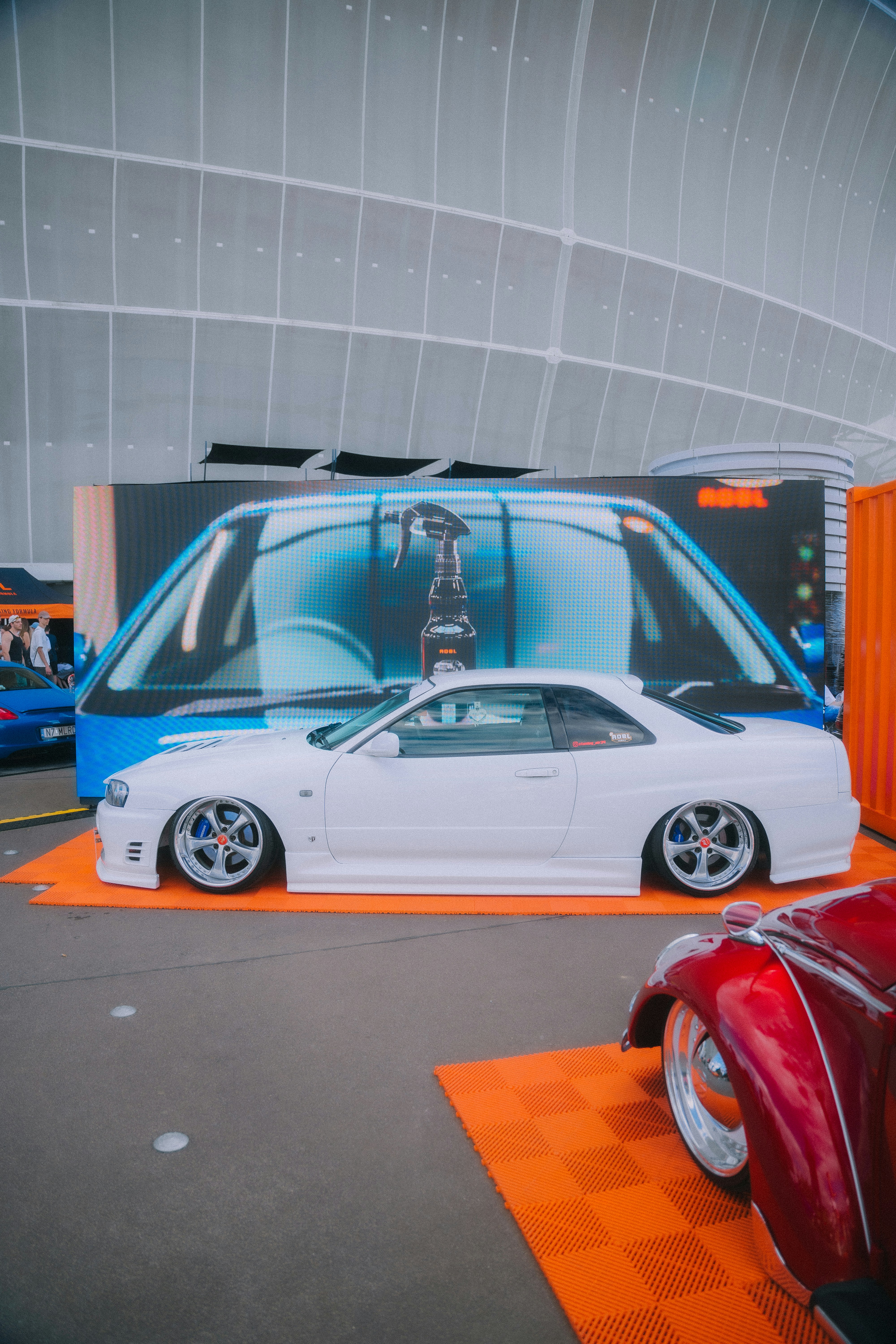 カーショーで白い車が展示されています。