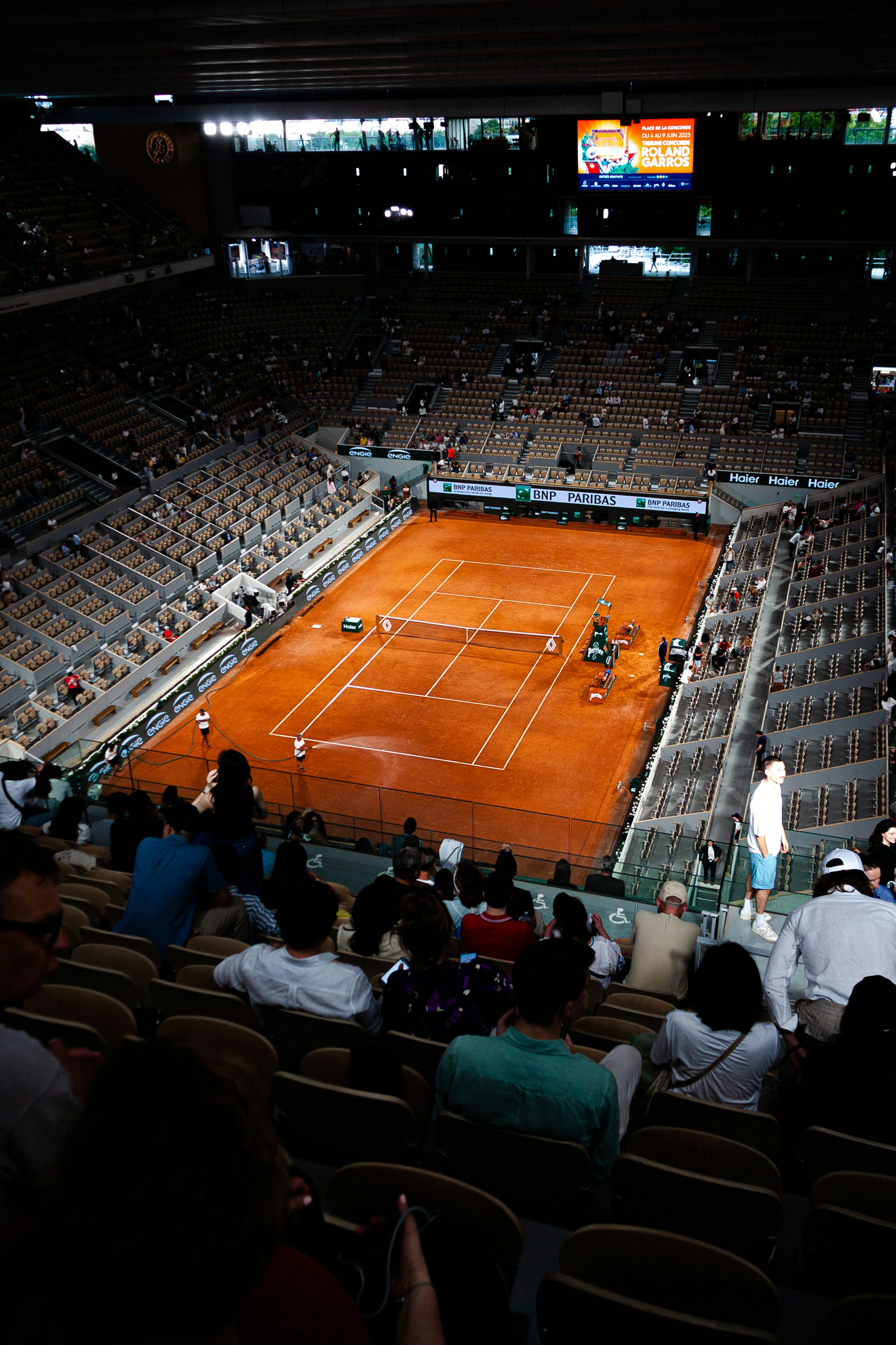 Match de tennis dans une vaste arène.