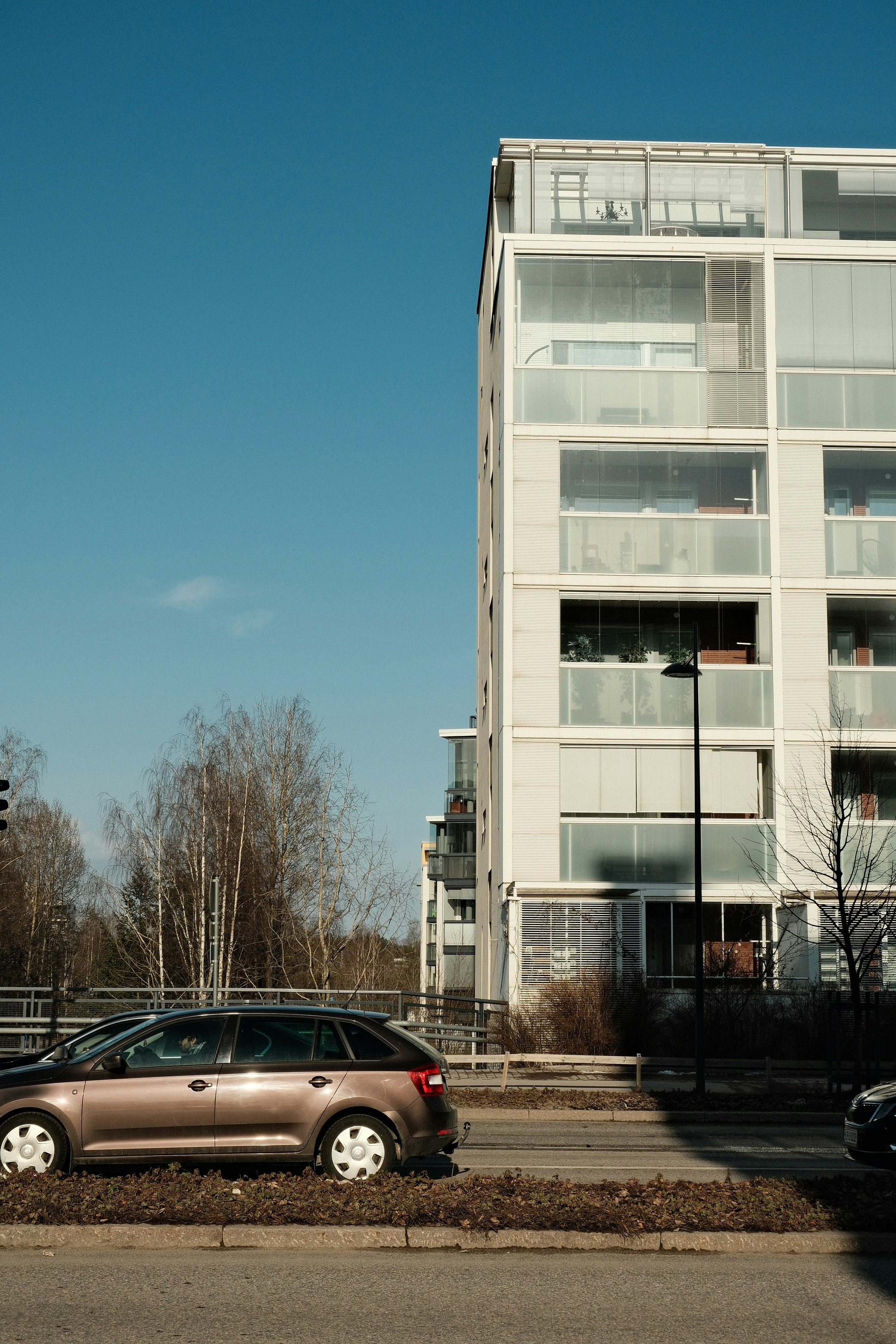 Modernes Mehrfamilienhaus hebt sich vor blauem Himmel ab.