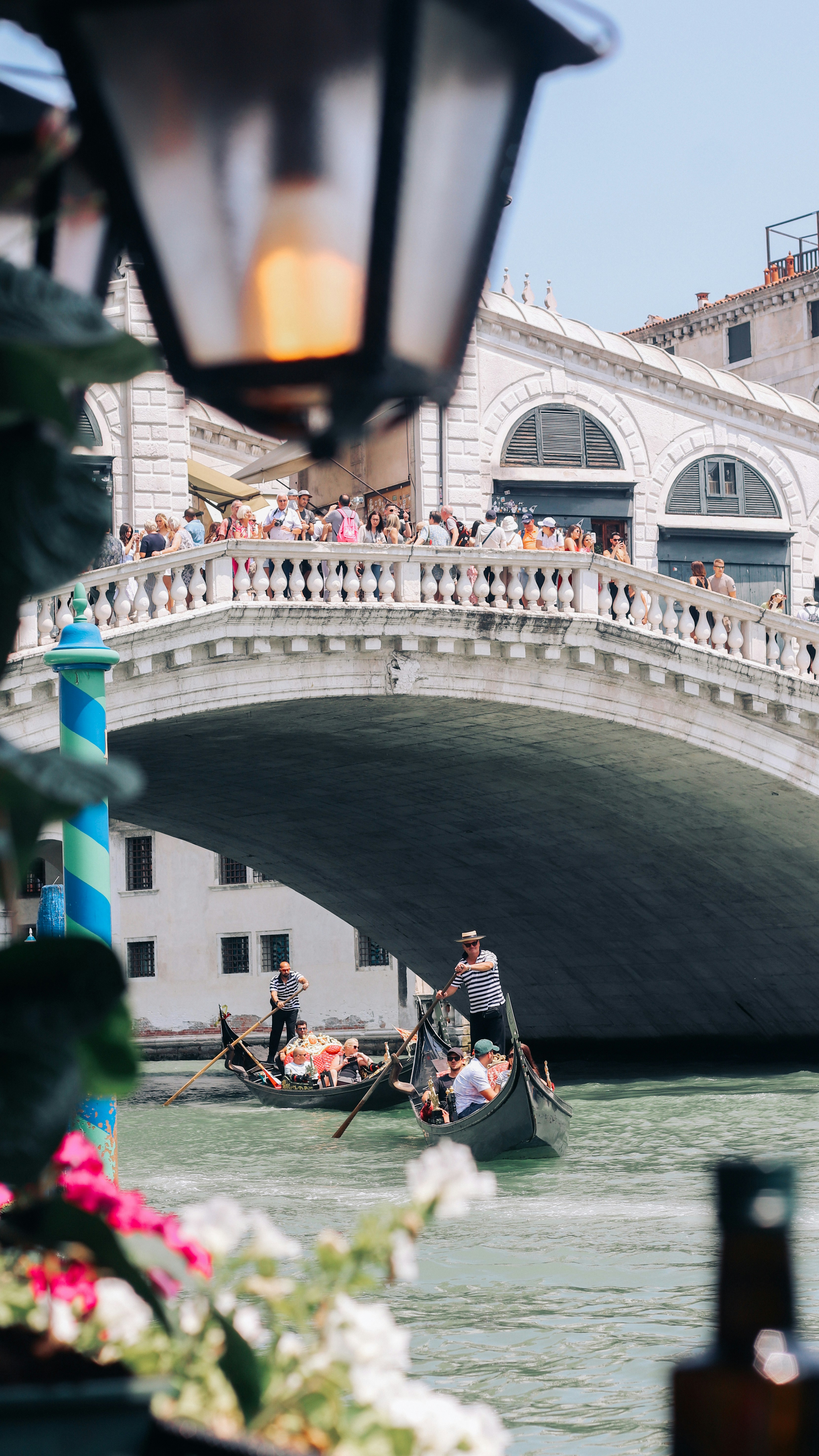 Gondolas pass under a bridge in venice.