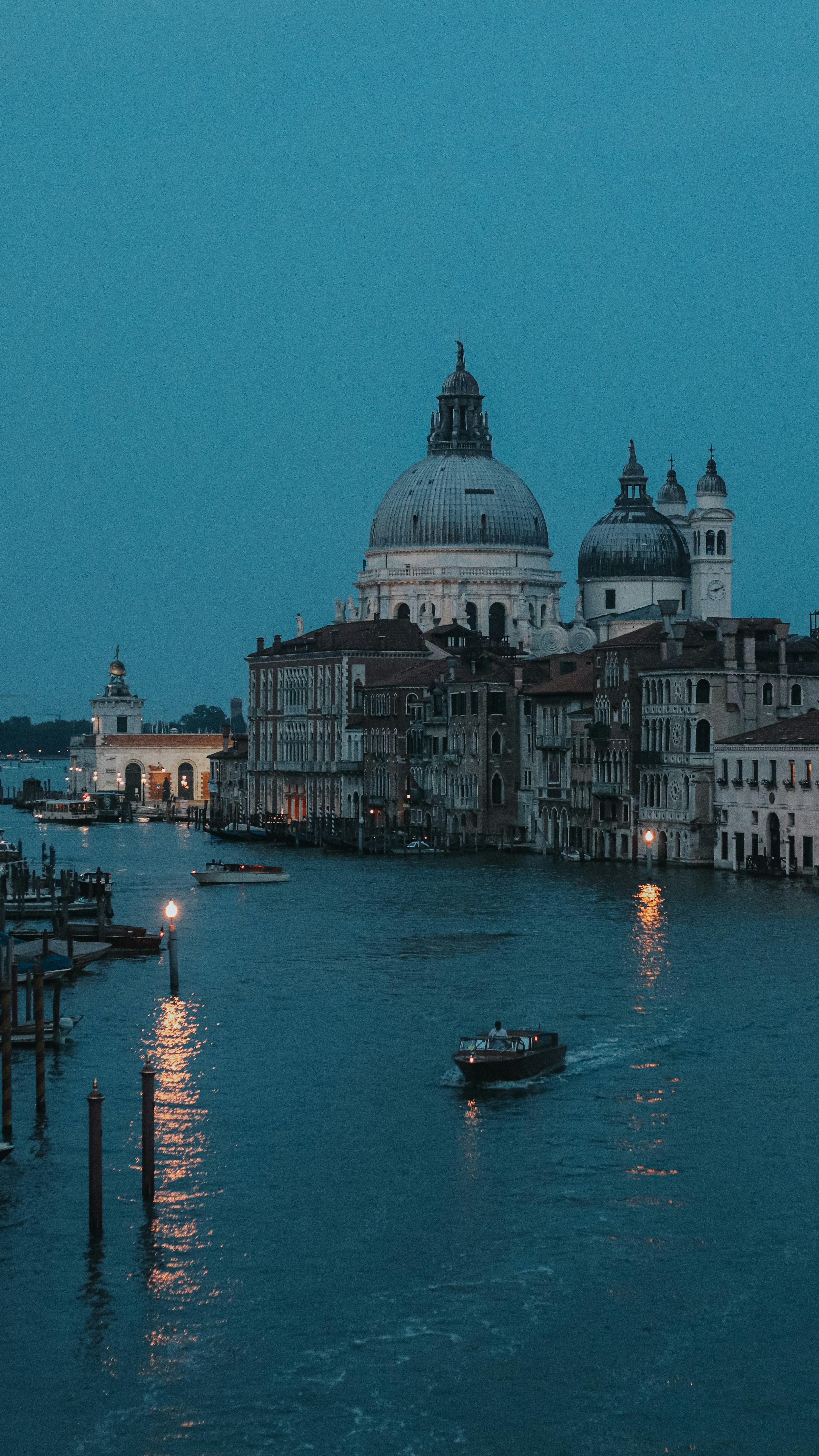 Venice, italy, at dusk; a boat glides through canals.