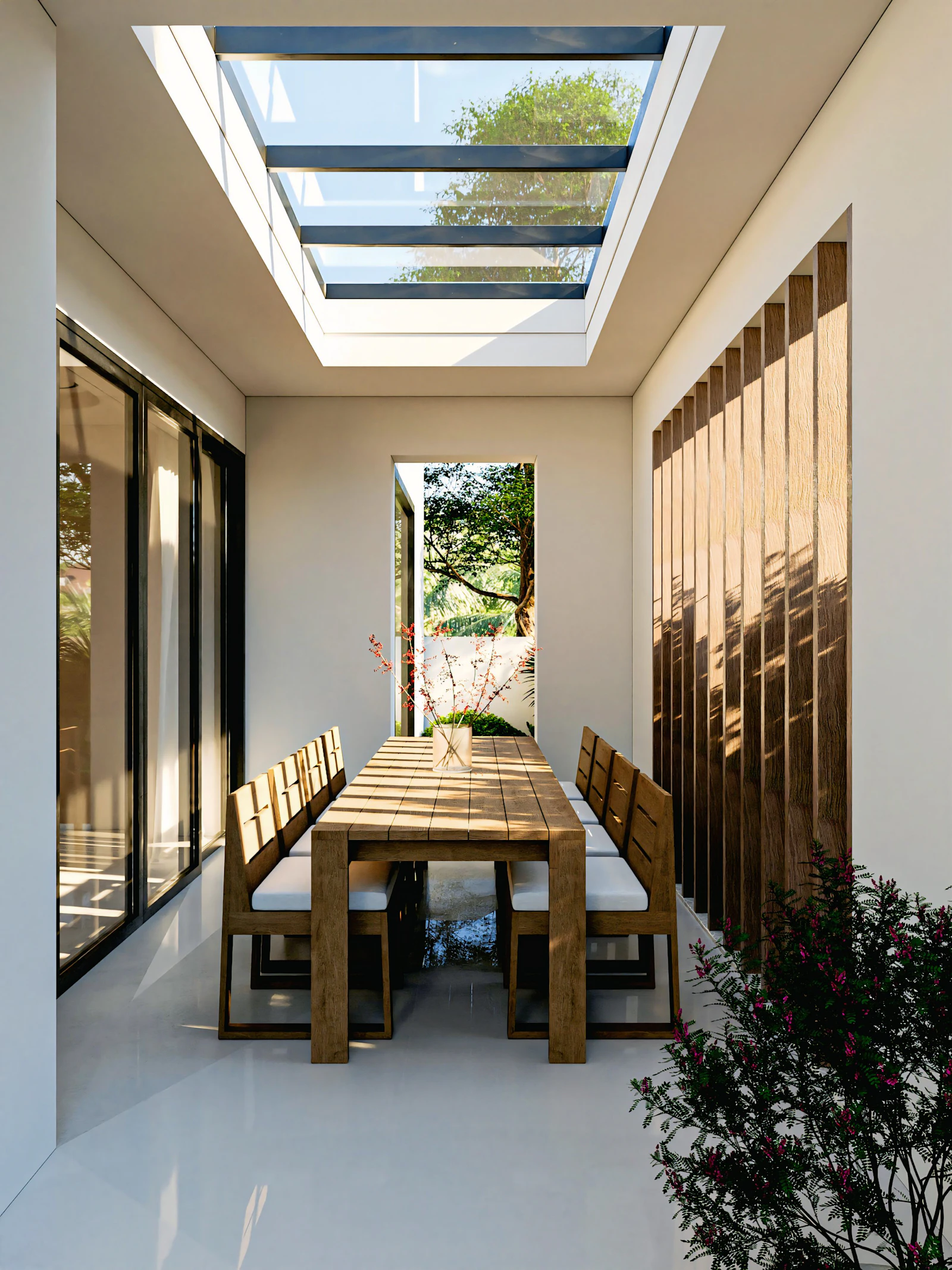 Long dining table under a roof light in a new rear extension