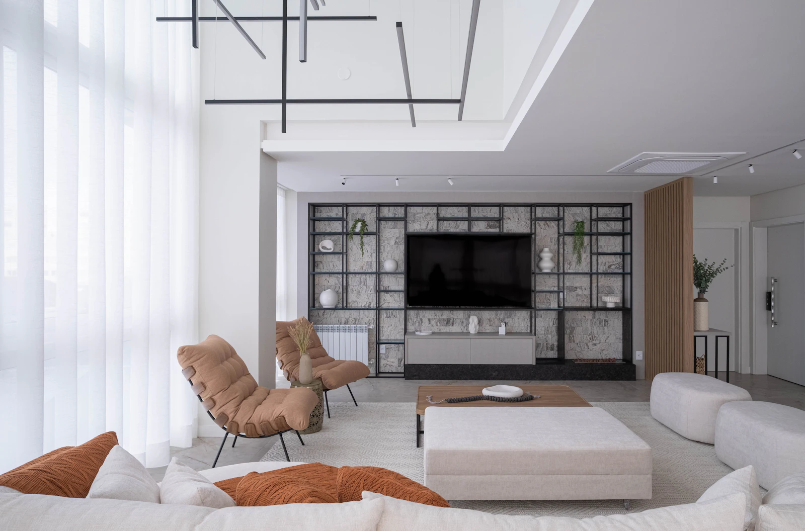 Sala de estar ampla e bem conservada, com luz natural filtrada por cortinas claras.