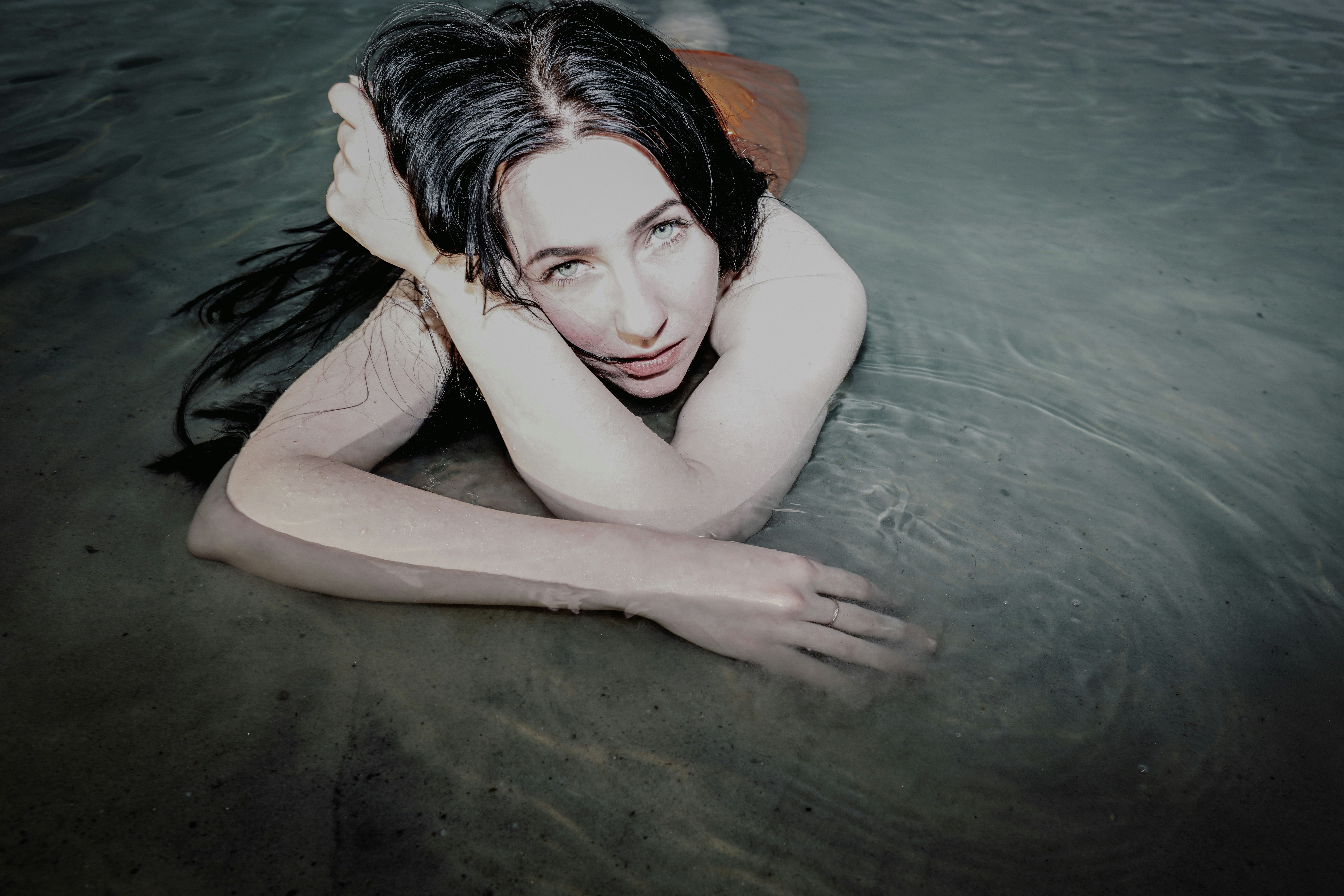Woman relaxing in water, looking at the viewer.
