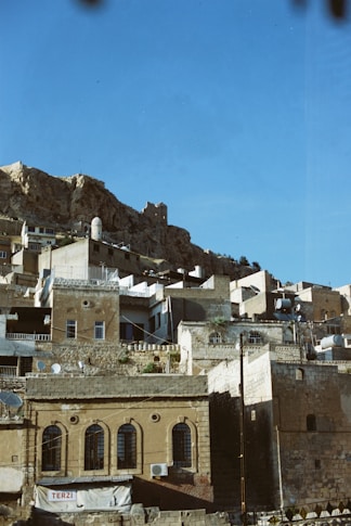 Old buildings cluster together beneath a mountain.
