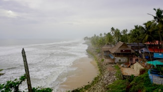 Beach houses sit along the stormy coast.