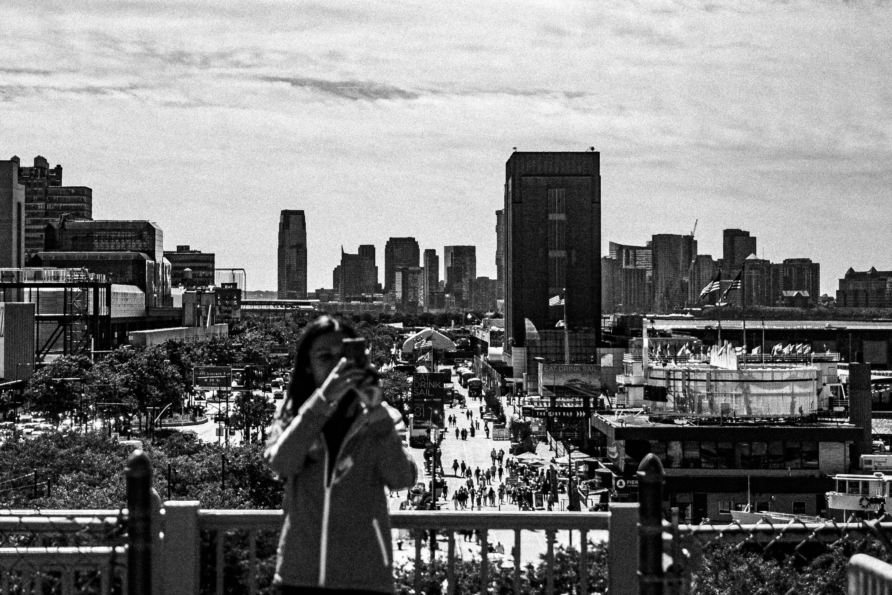 Two people photograph a city skyline.