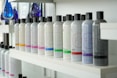 Bottled hair products are neatly arranged on a shelf.