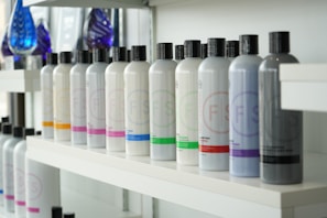 Bottled hair products are neatly arranged on a shelf.