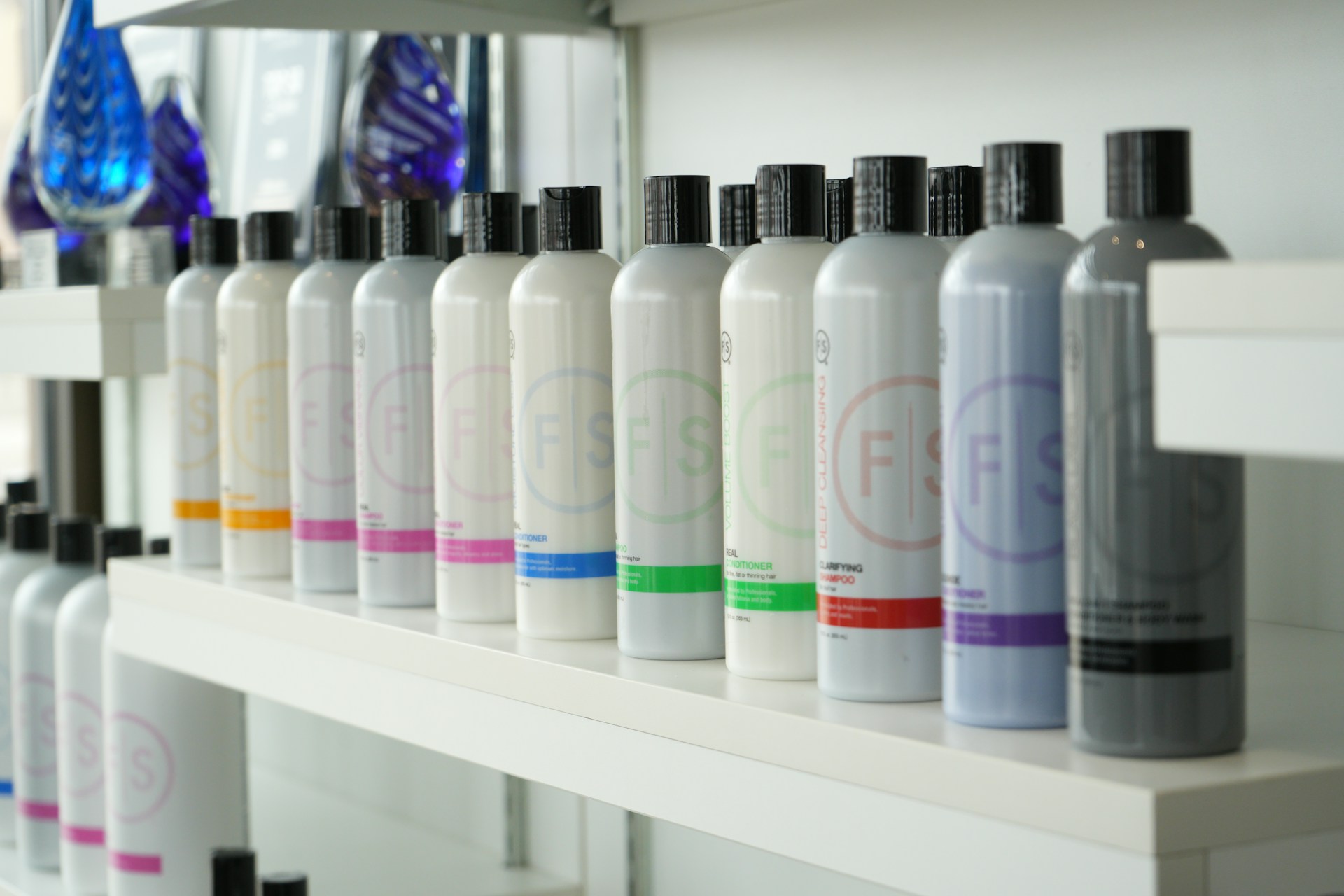 Bottled hair products are neatly arranged on a shelf.