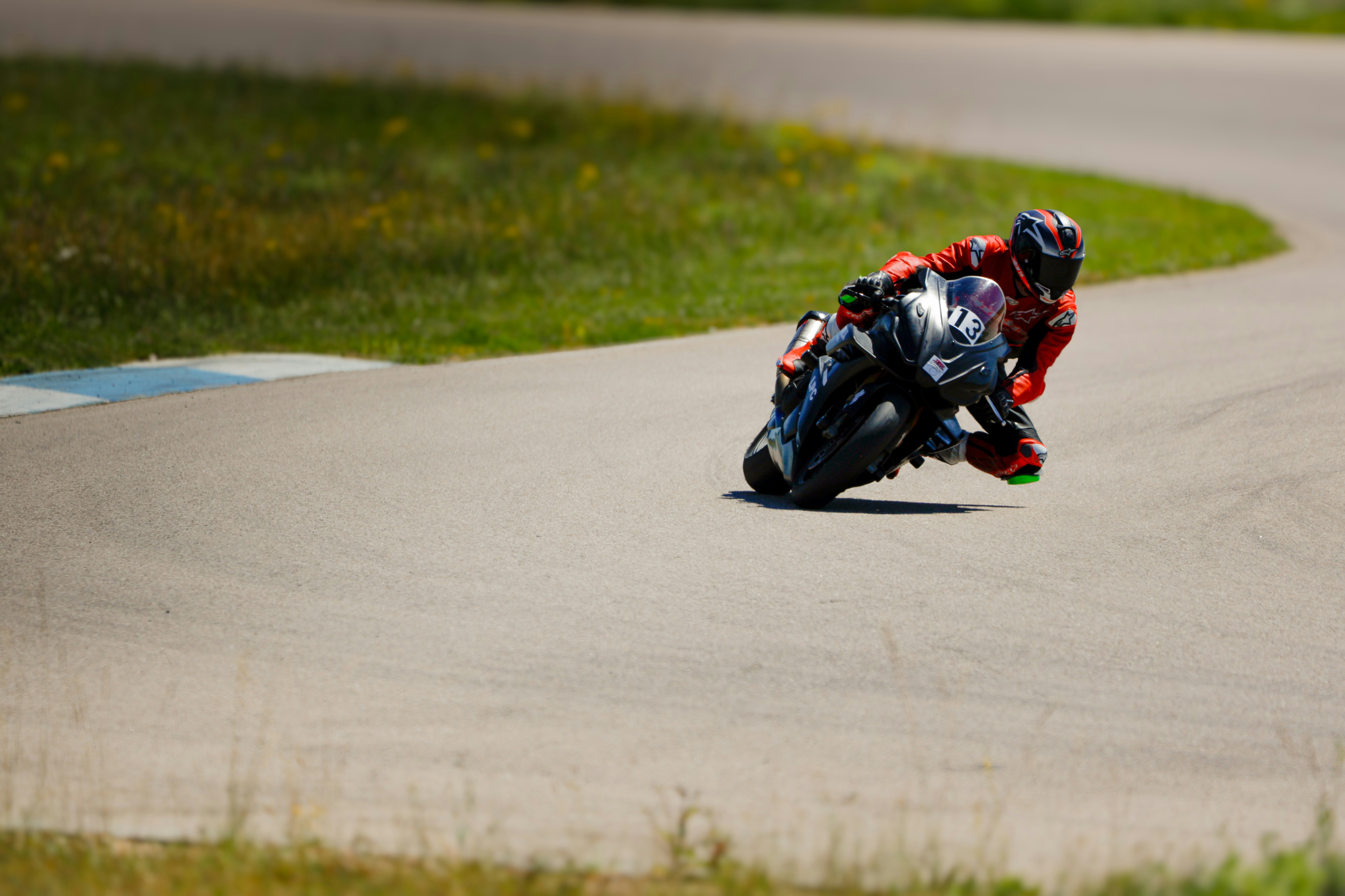 A motorcyclist leans into a turn on a racetrack.