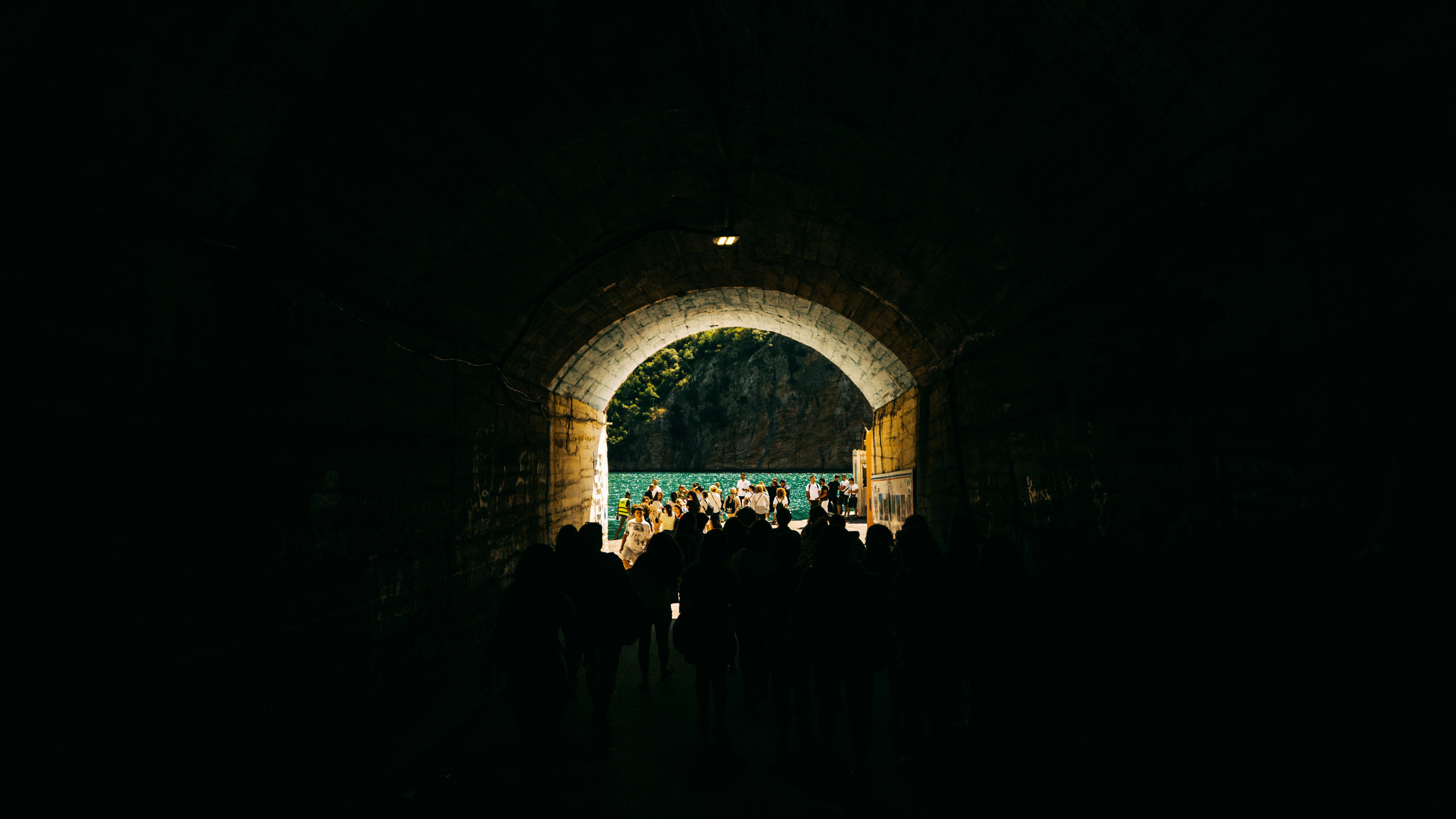 People walk towards the light at the tunnel's end.