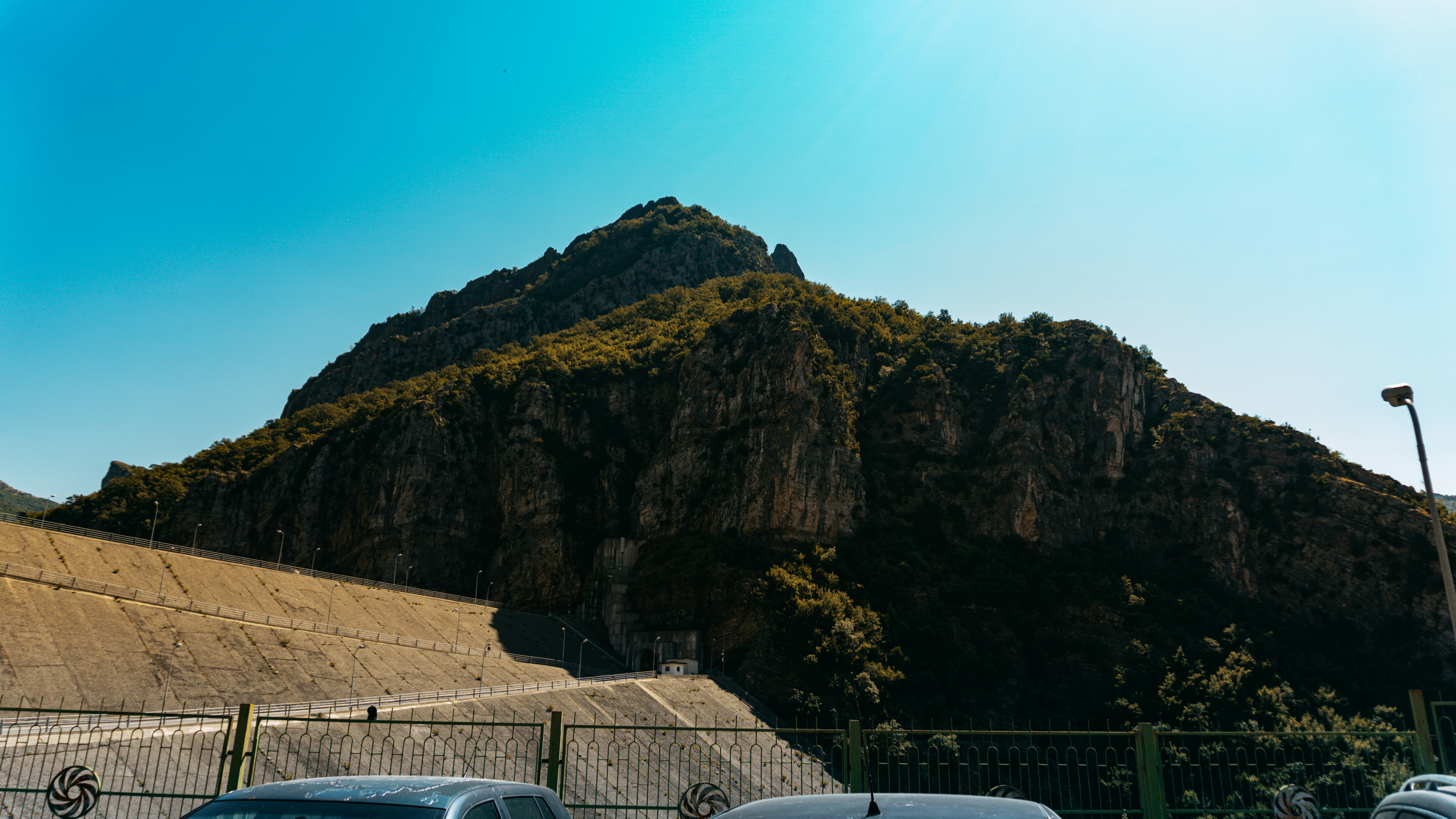 A rocky mountain peaks against a clear blue sky.