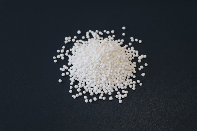 A pile of white beads on a dark background.