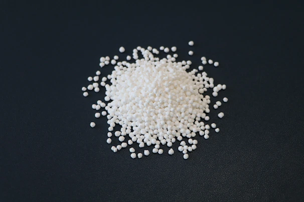 A pile of white beads on a dark background.