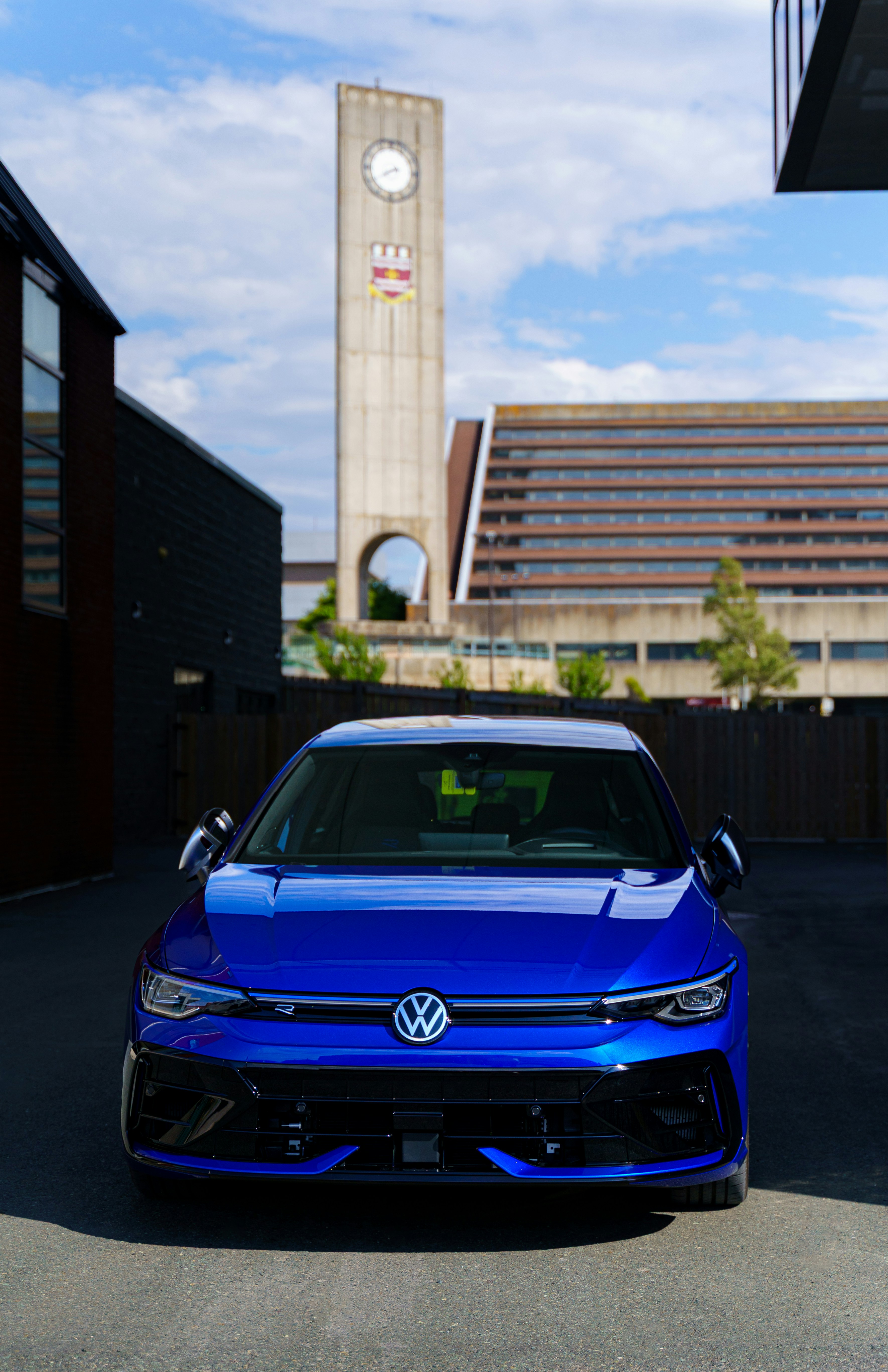 A blue volkswagen car is parked in a town square