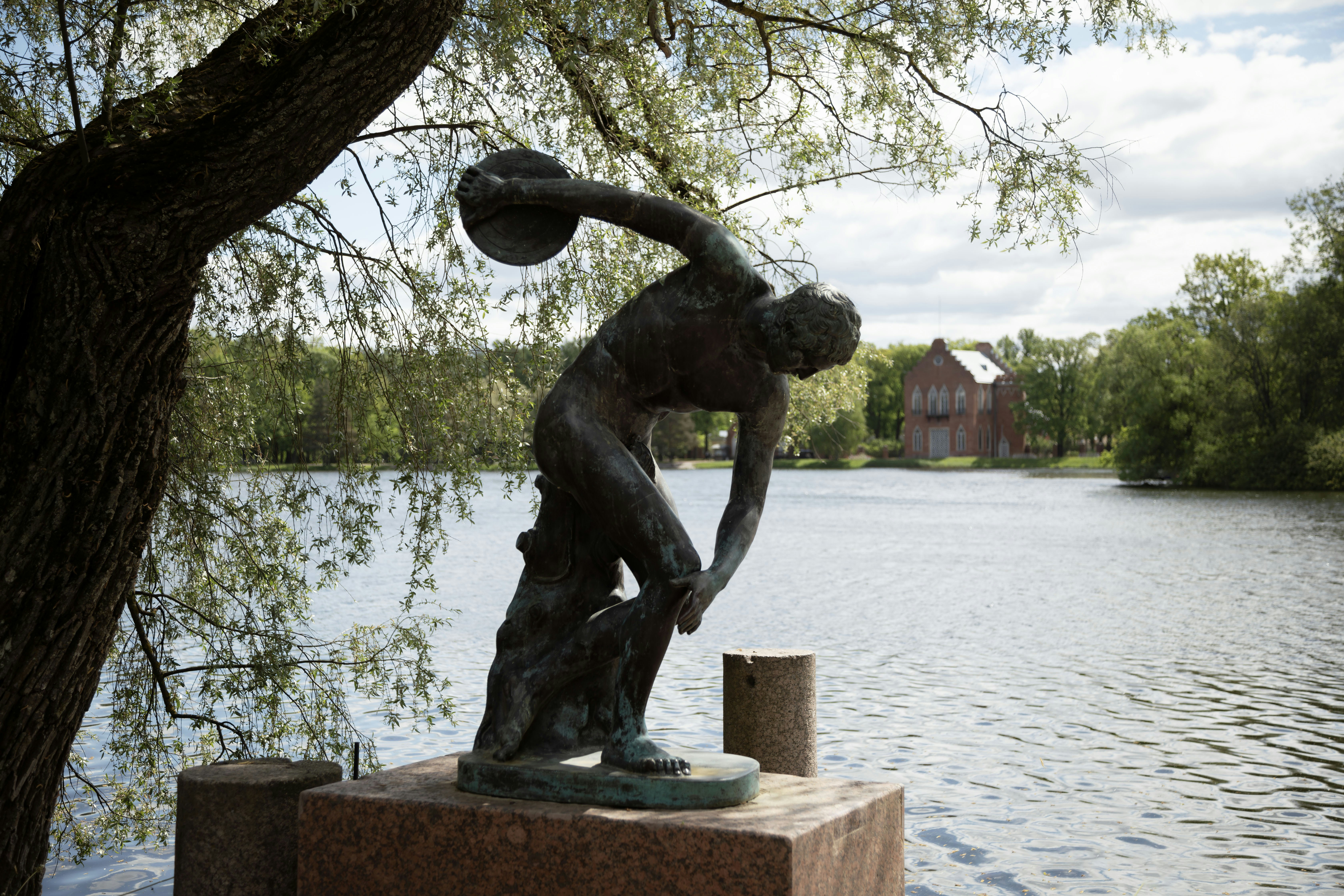Una estatua de un discóbolo junto a un lago.