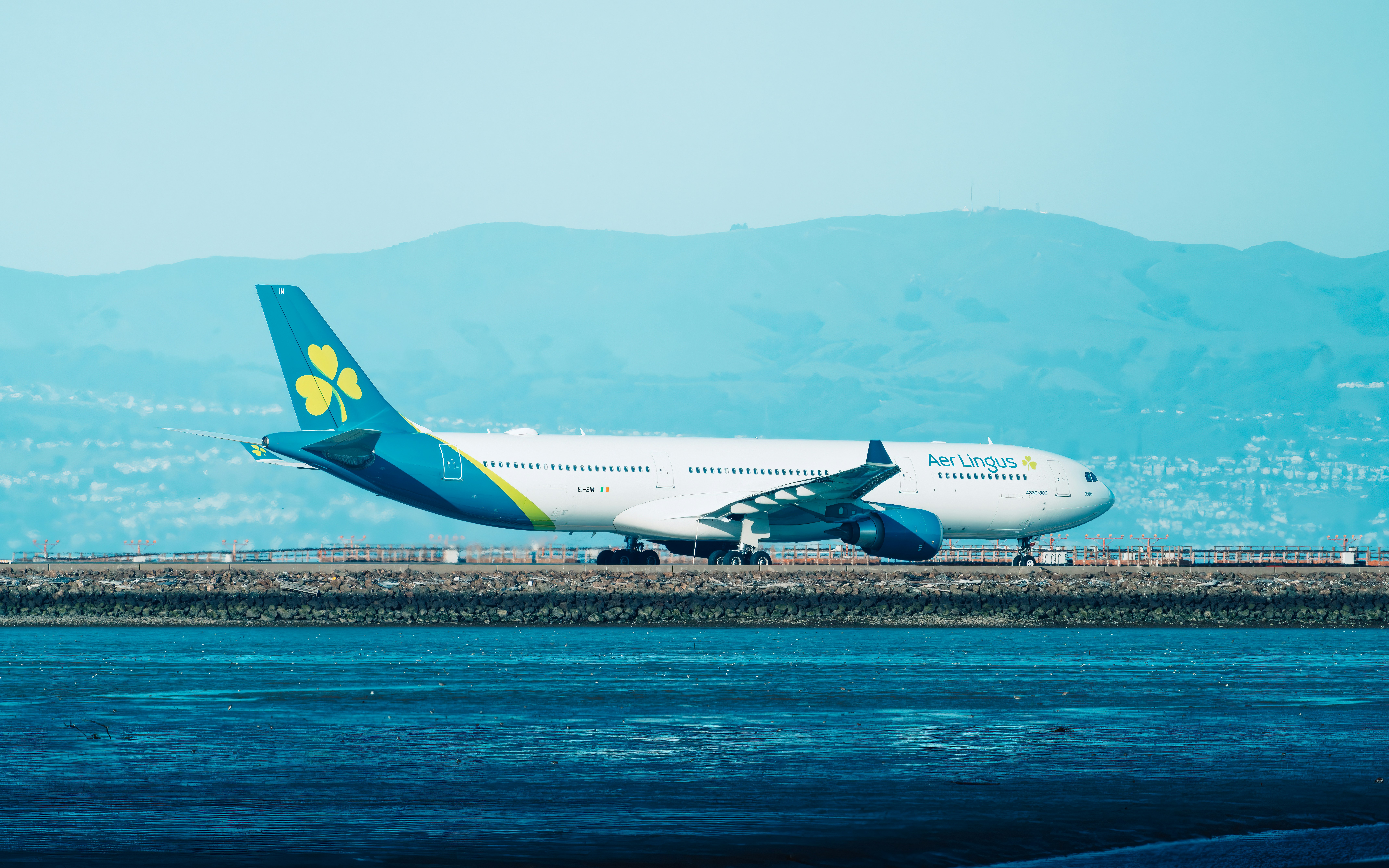 An aer lingus plane is taxiing on the runway.