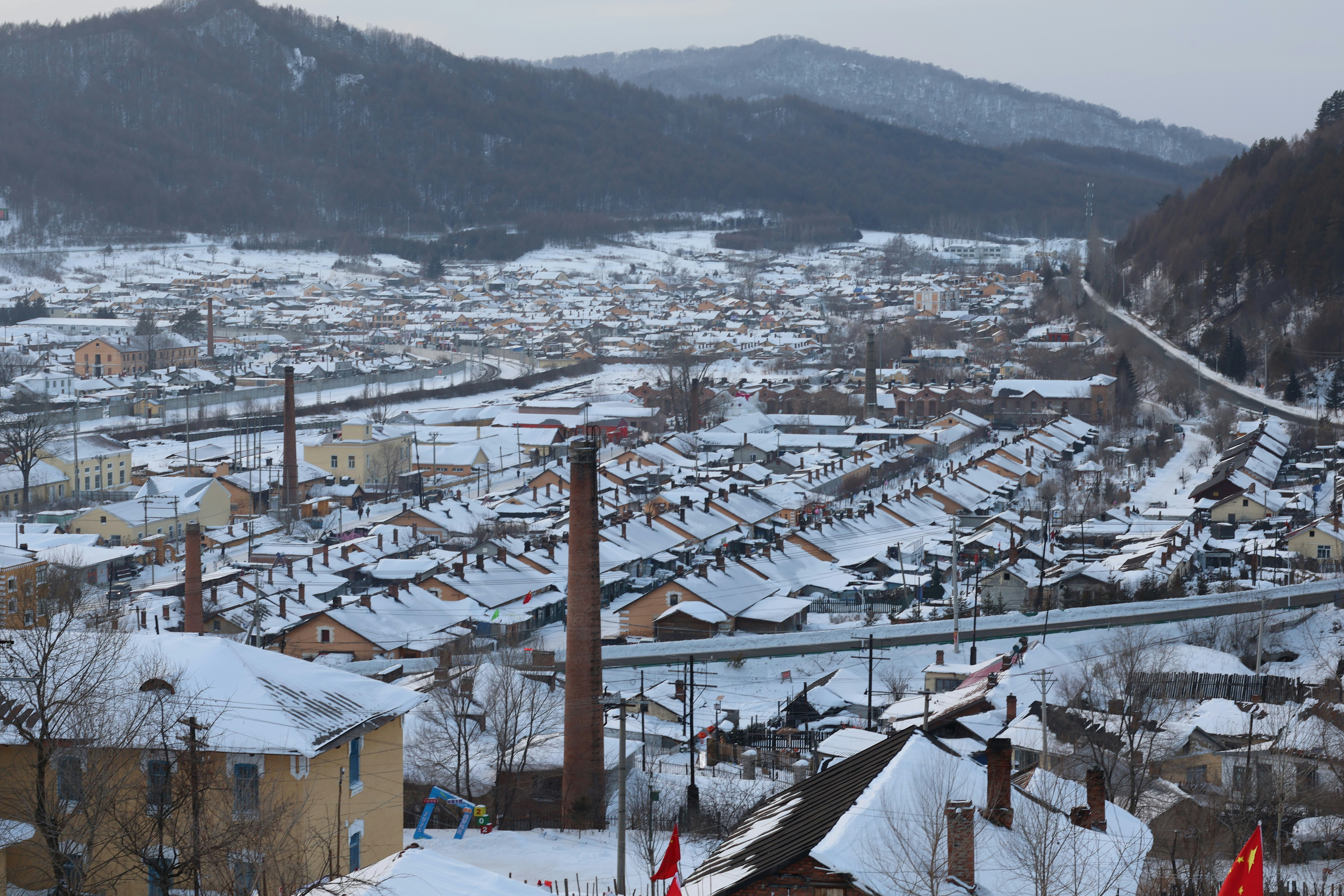 A snow-covered town sits nestled amidst mountains.