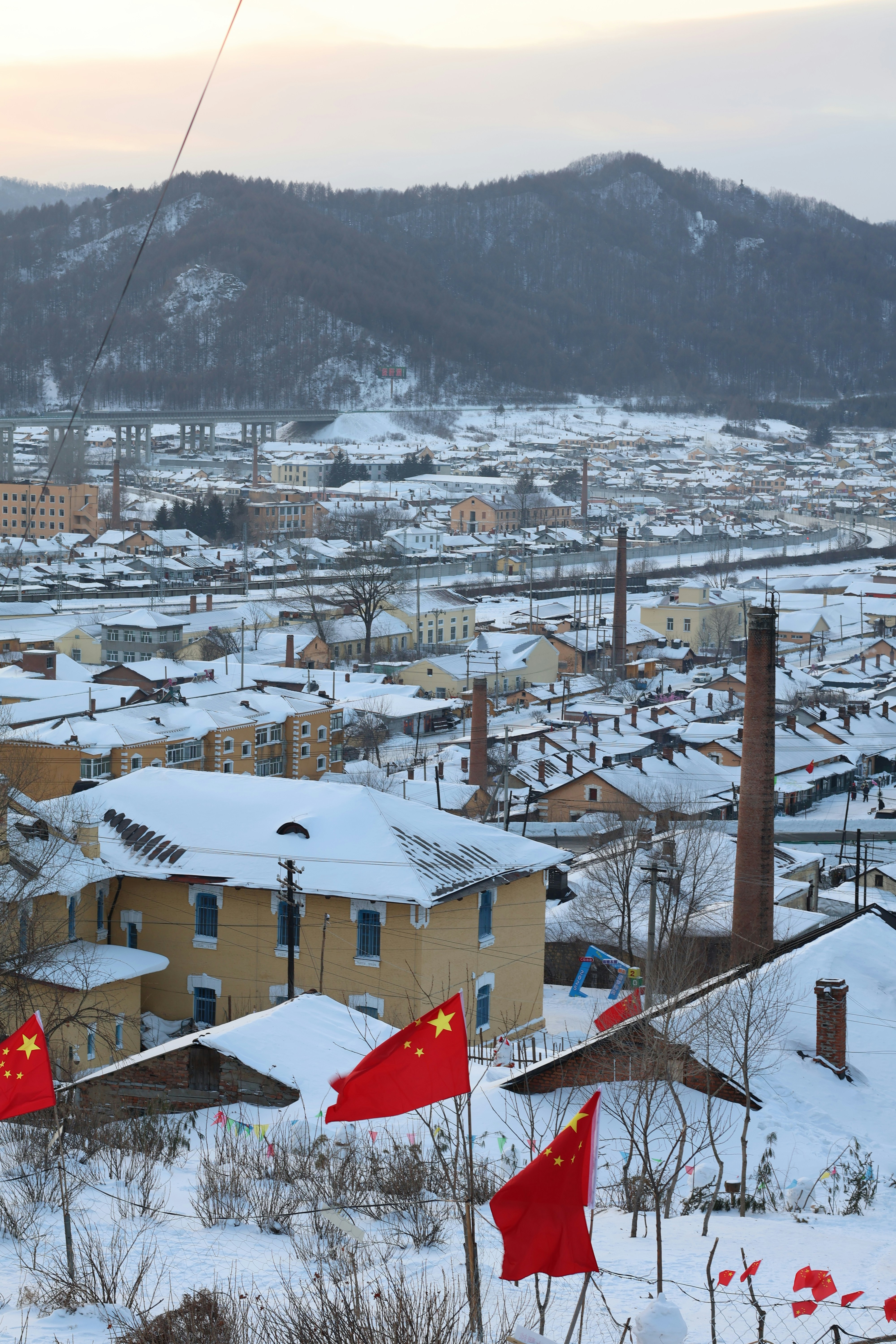 Snowy town with chinese flags and mountains.