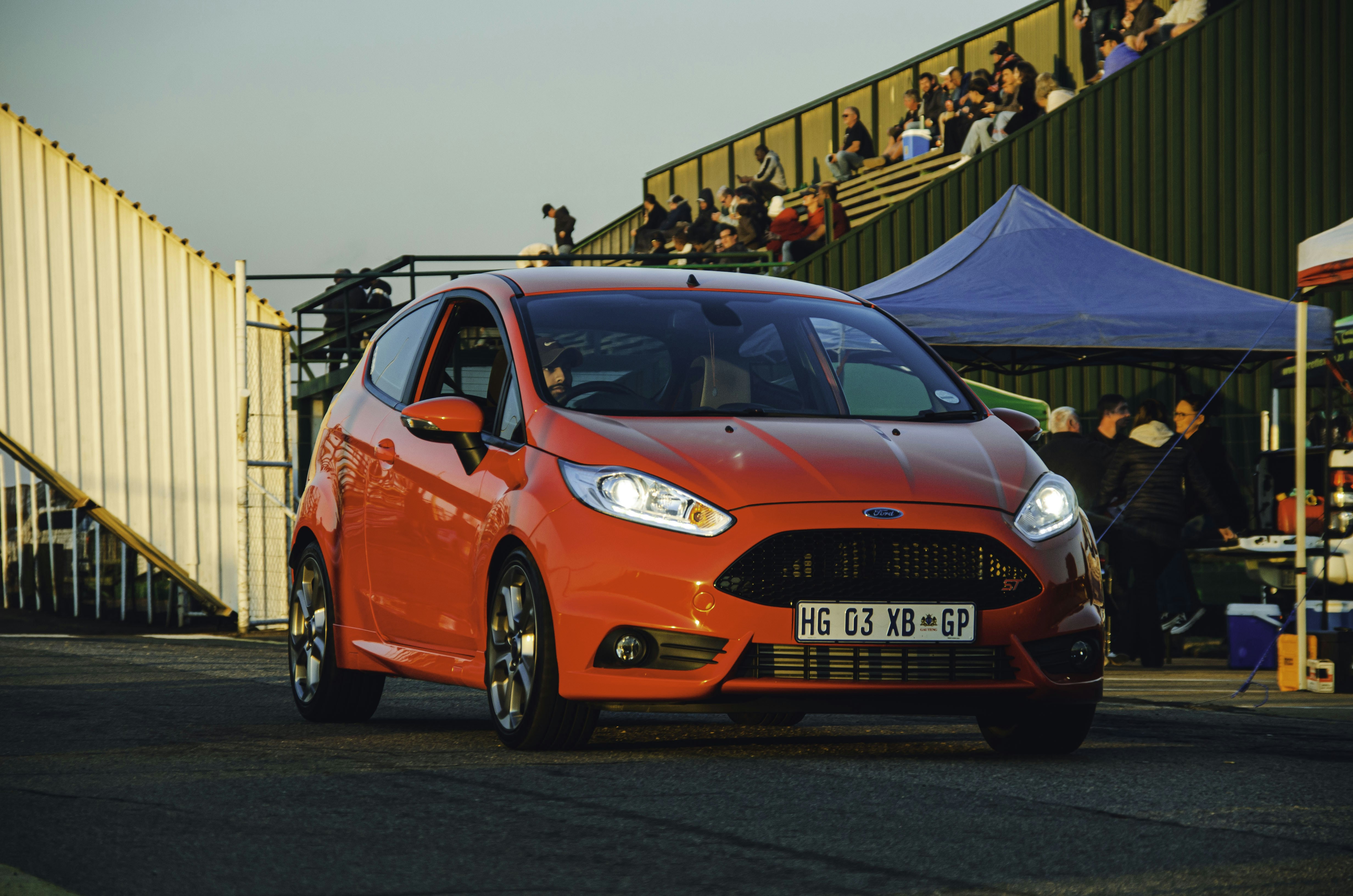 A red ford fiesta speeds down a track.