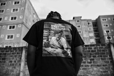 Man wears a pablo escobar shirt in an urban area.