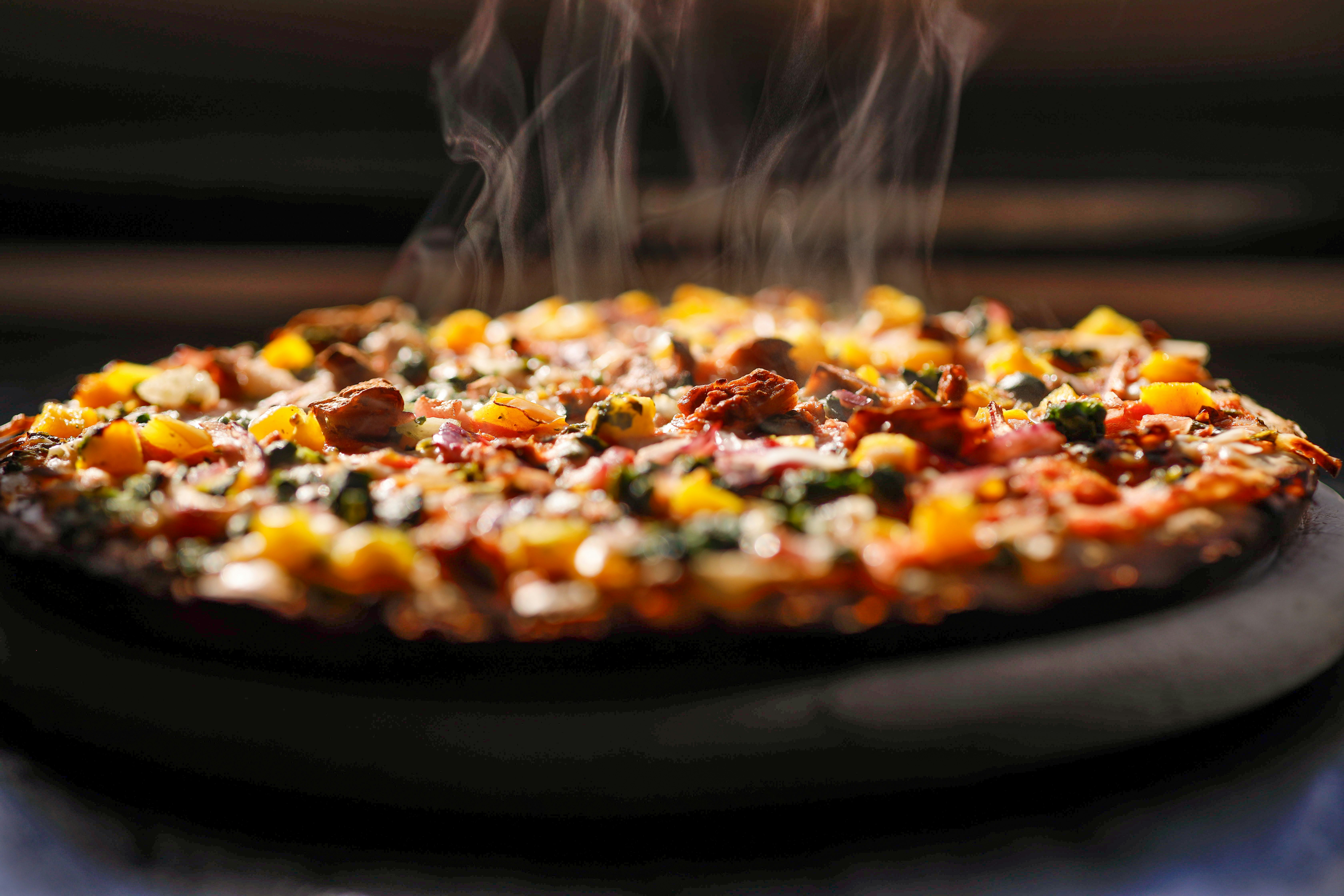 Steaming hot pizza with toppings
