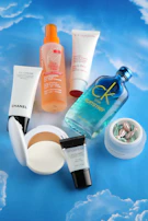 Cosmetics and beauty products are arranged on a blue background.