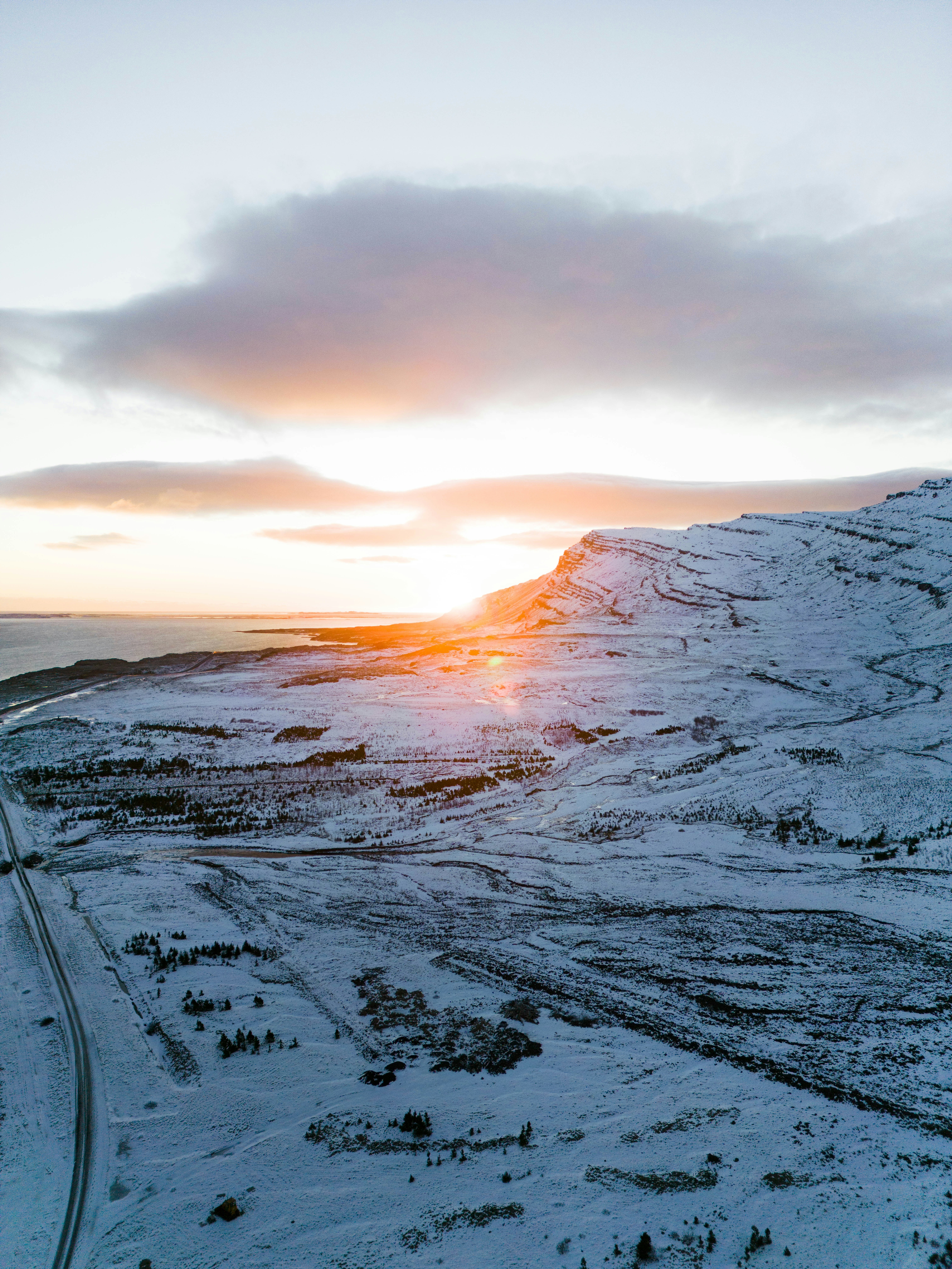 Sunset illuminates a snowy mountain landscape.