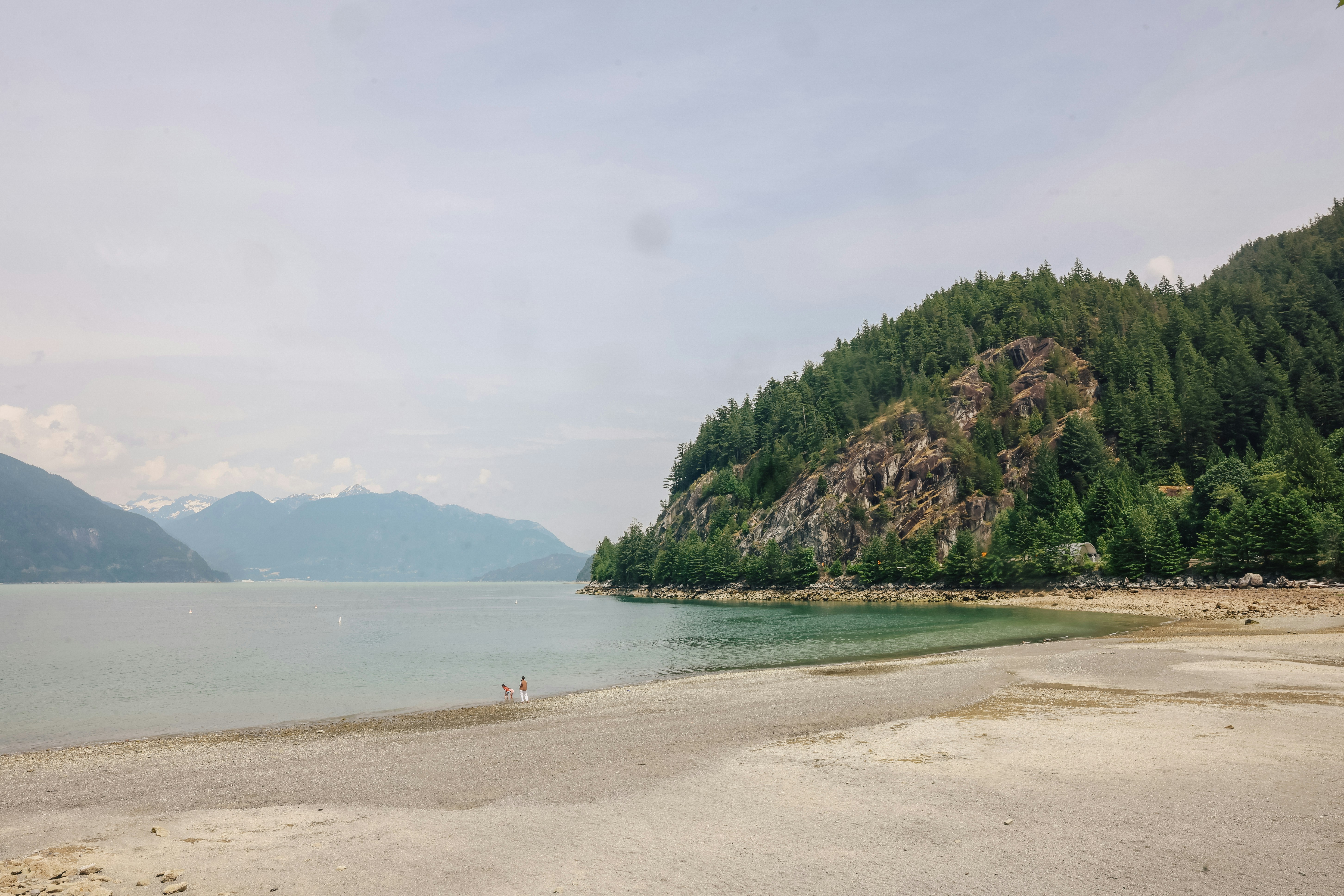 A scenic beach with a mountain in the background.