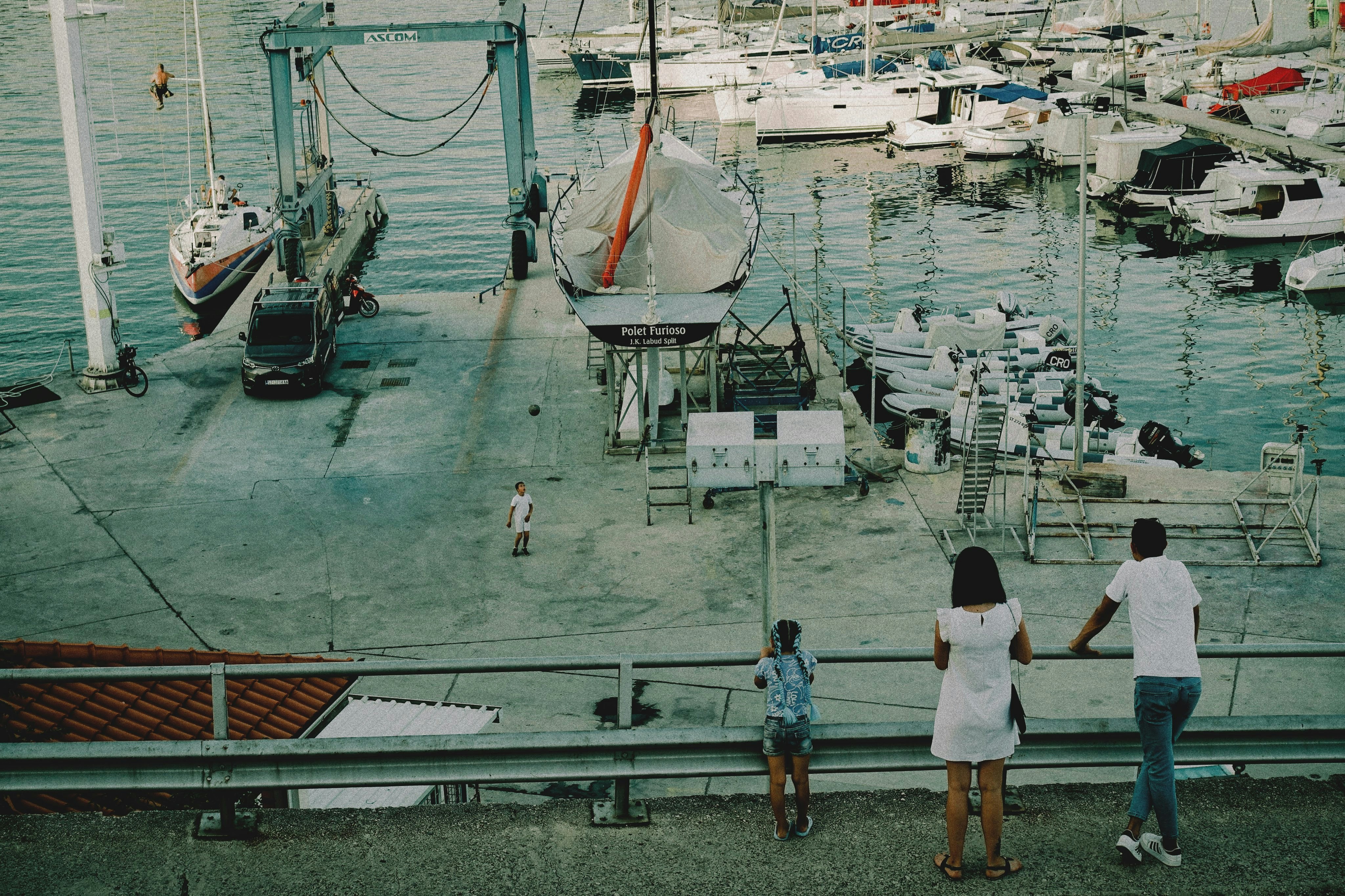 People watch boats in the harbor.