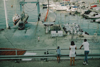 People watch boats in the harbor.