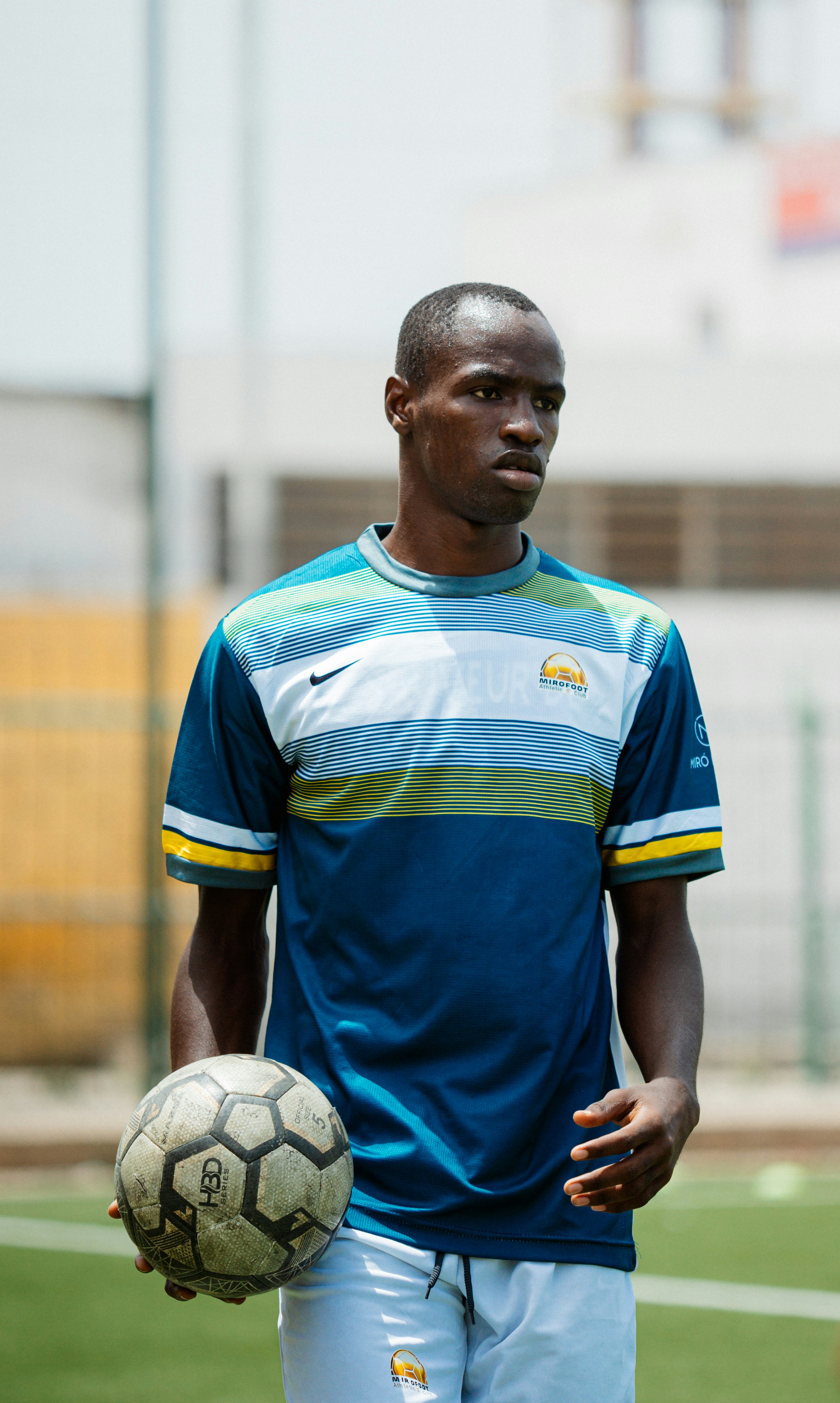 A soccer player holds the ball.