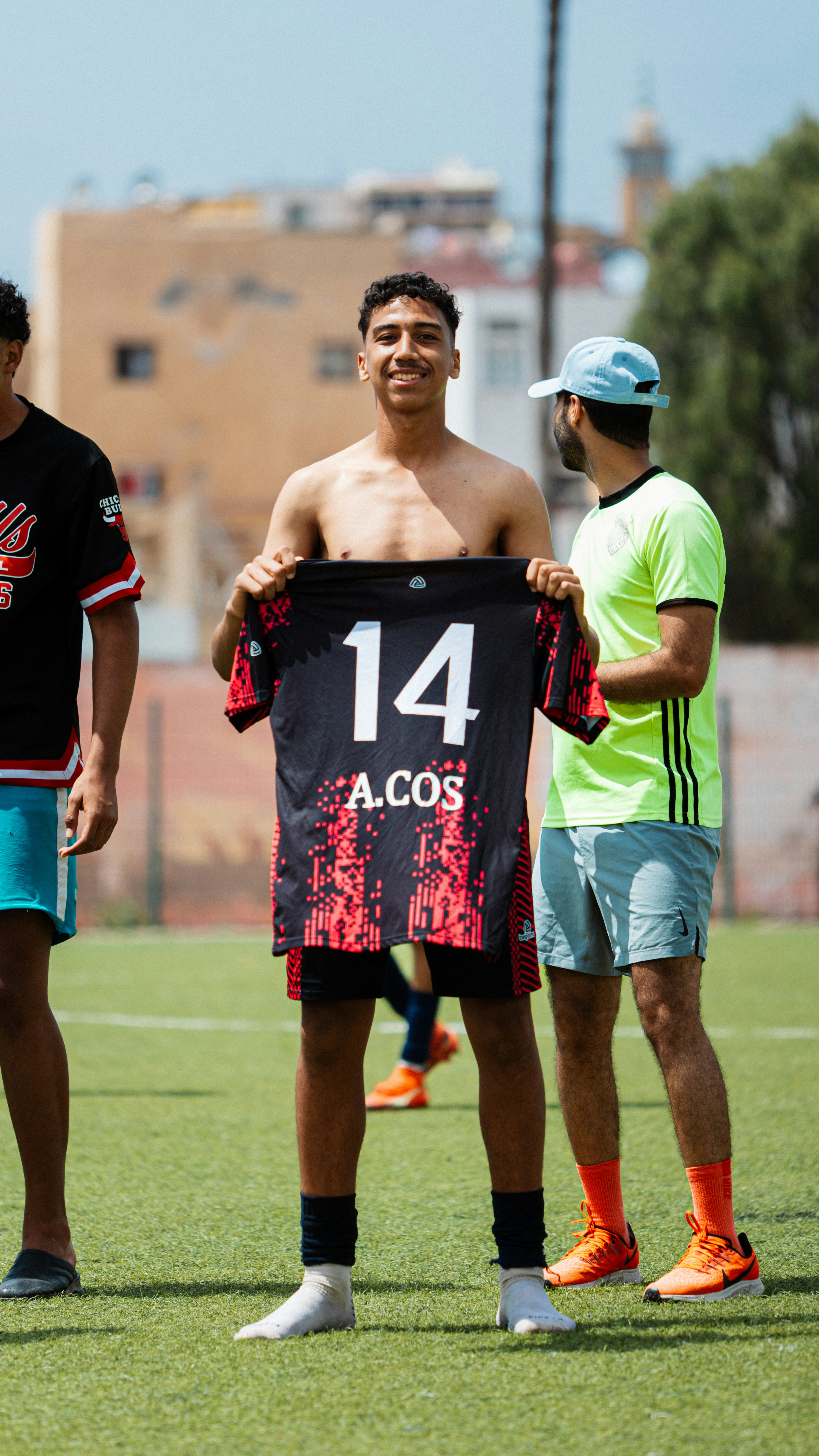 A man holds up a soccer jersey.