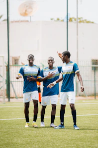 Three soccer players celebrate their win.