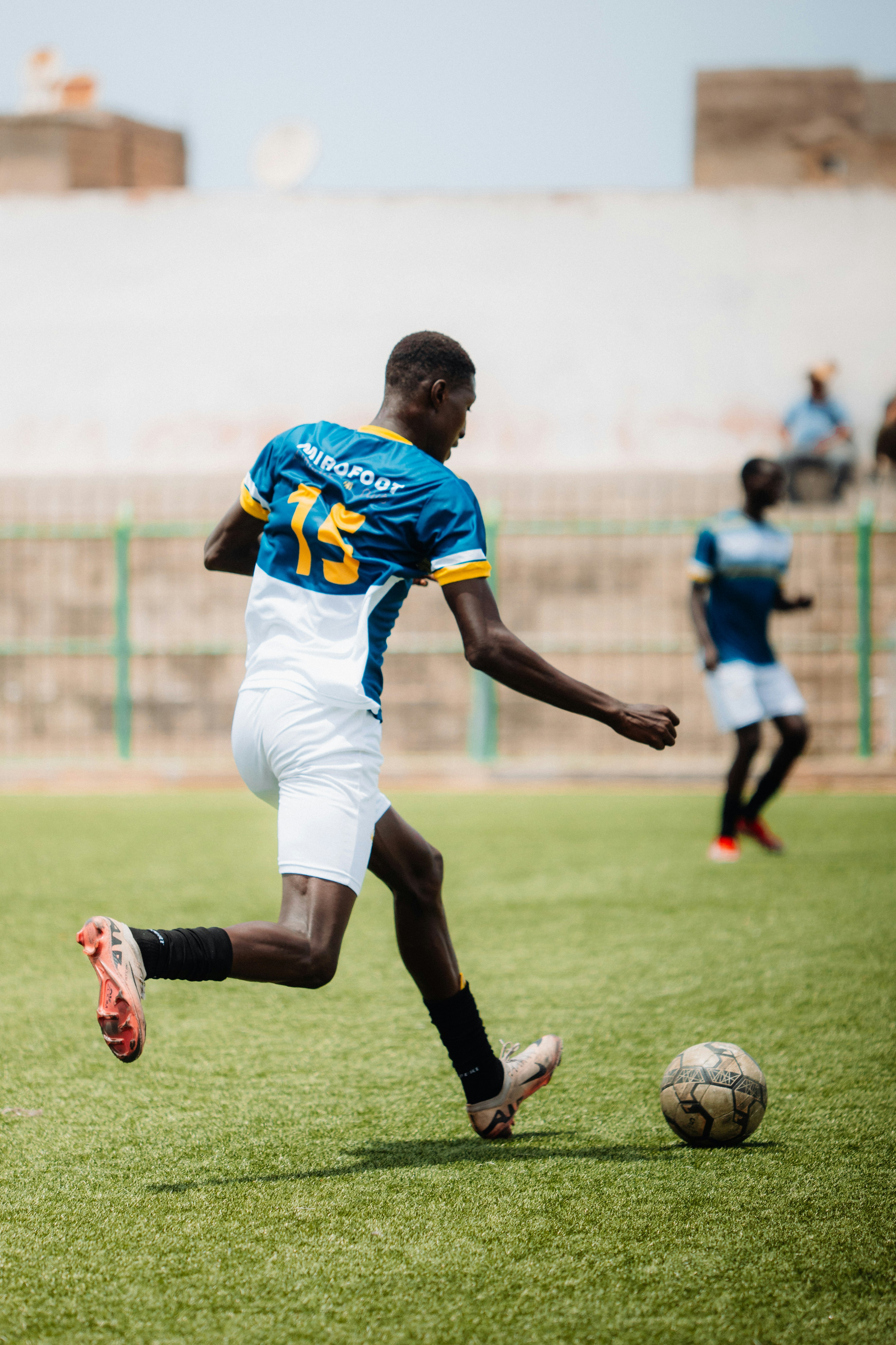 A soccer player kicks the ball during a game.