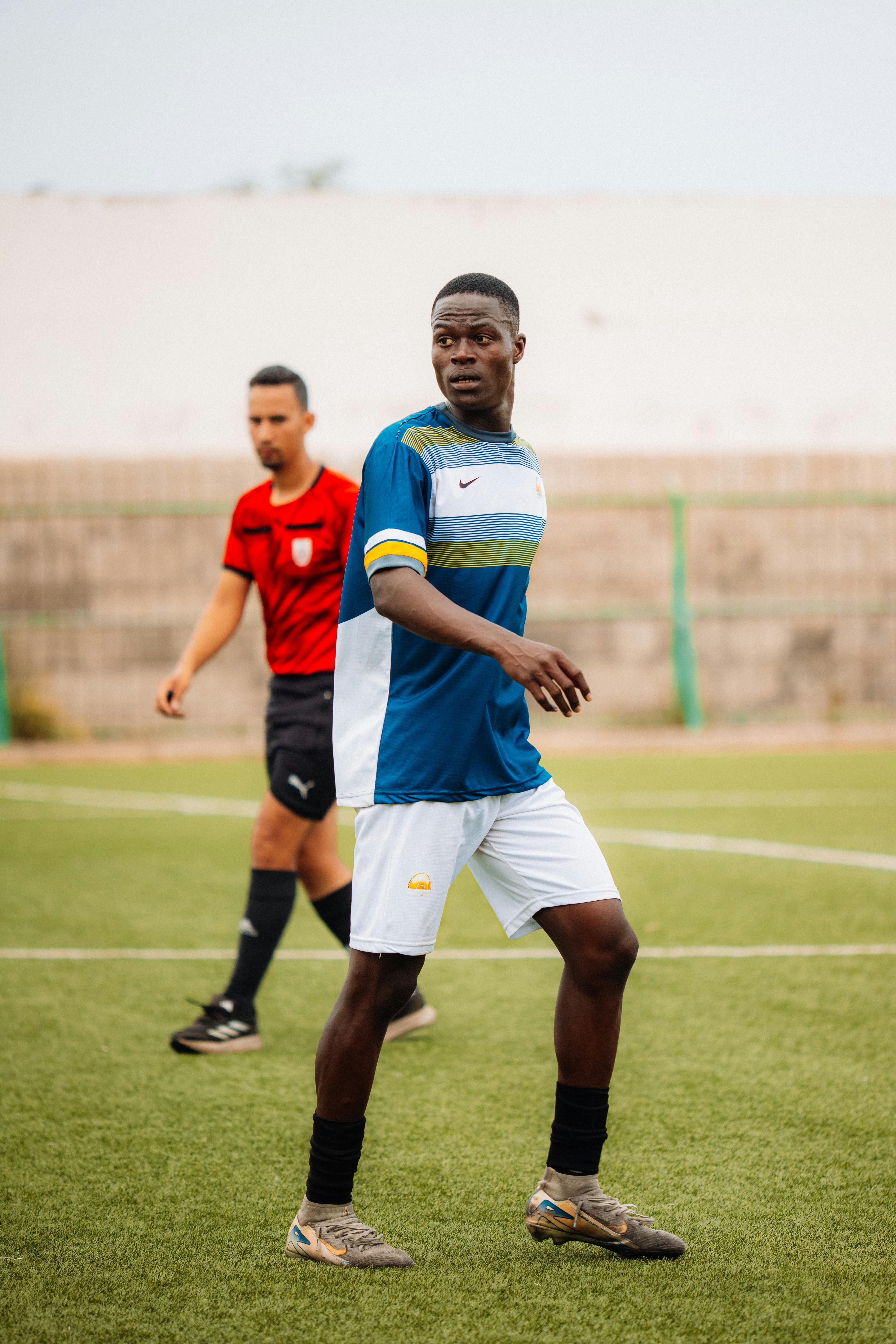 Two soccer players are on a green field.
