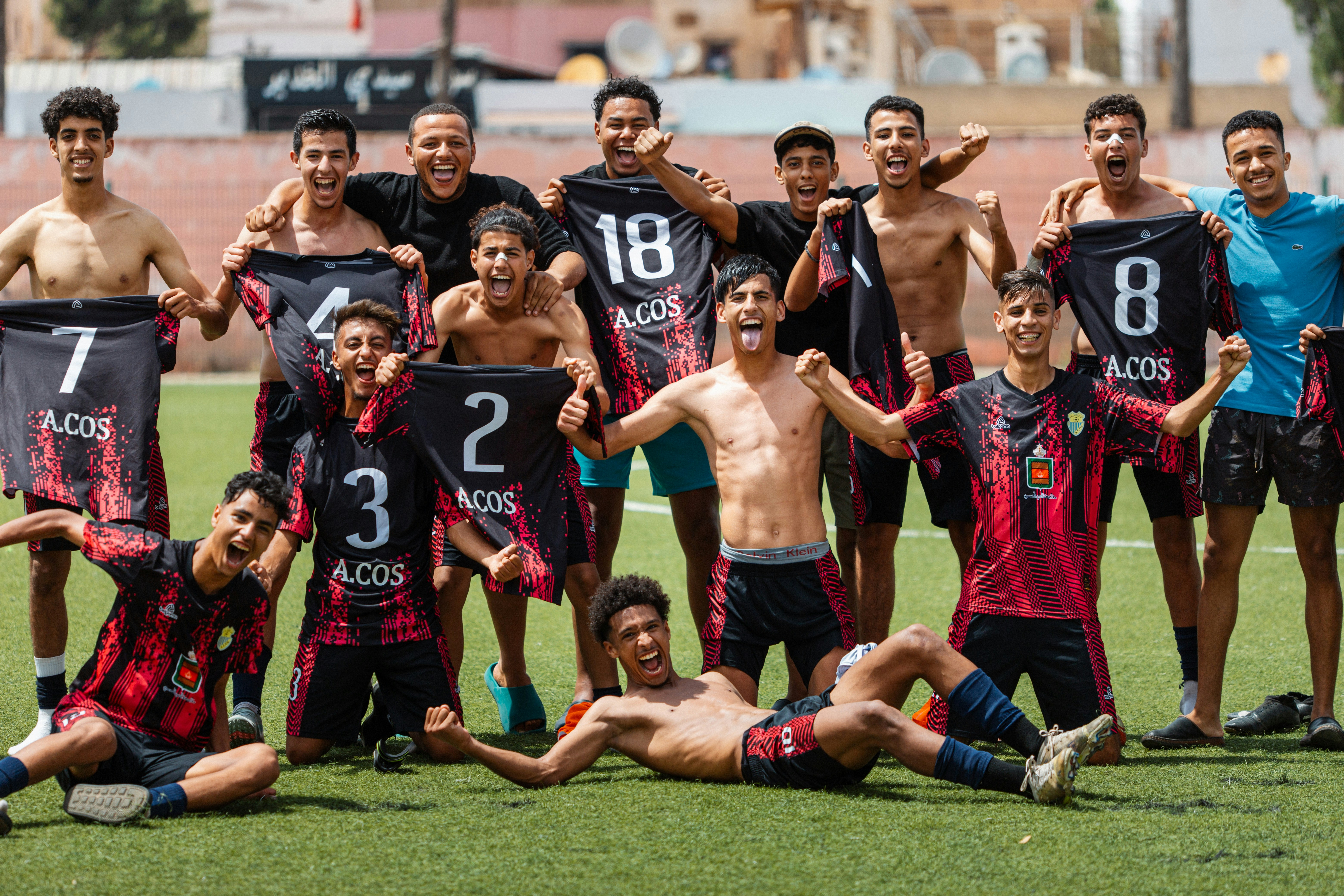 A soccer team smiles and celebrates a victory.