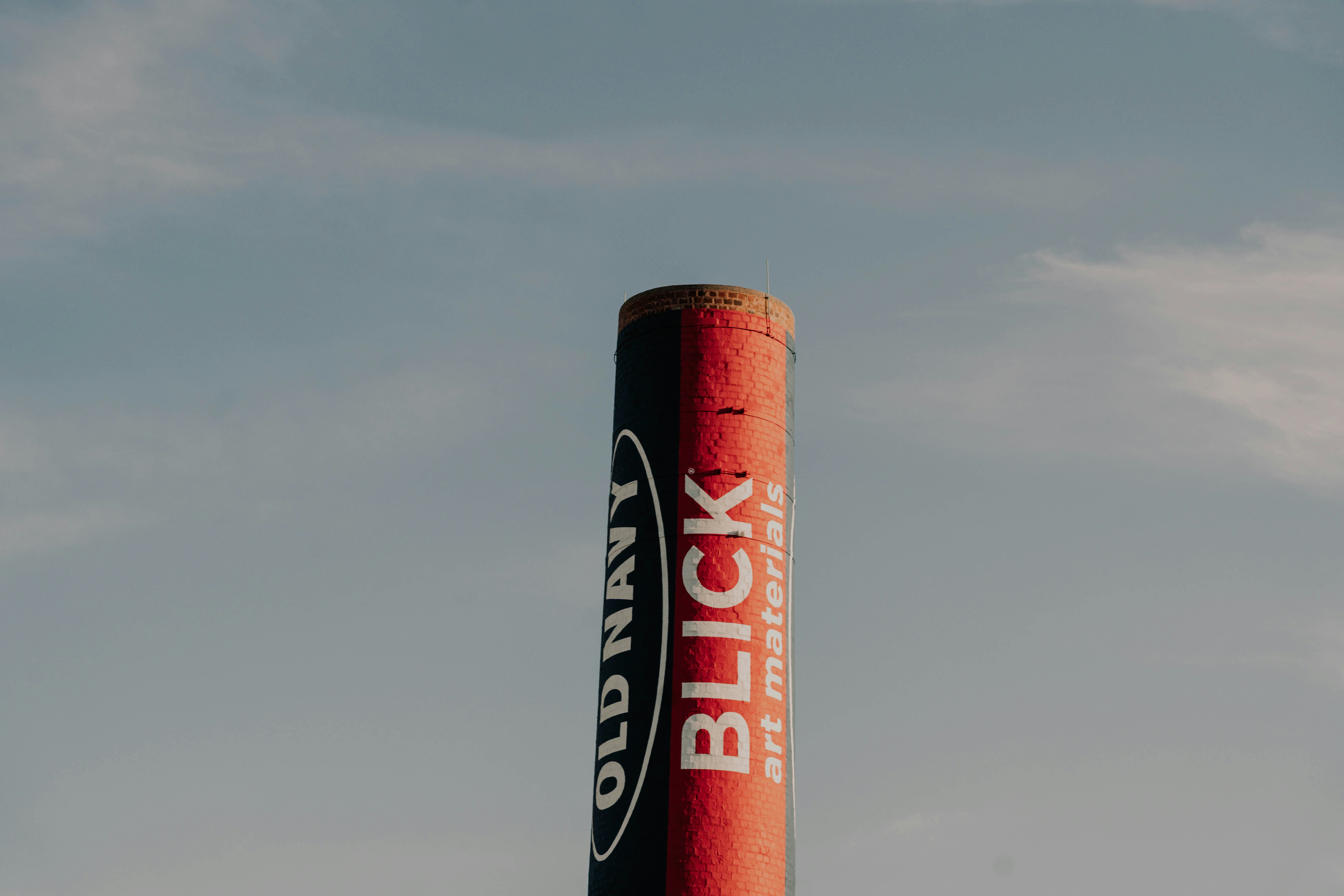 A blick art materials tube against a cloudy sky.