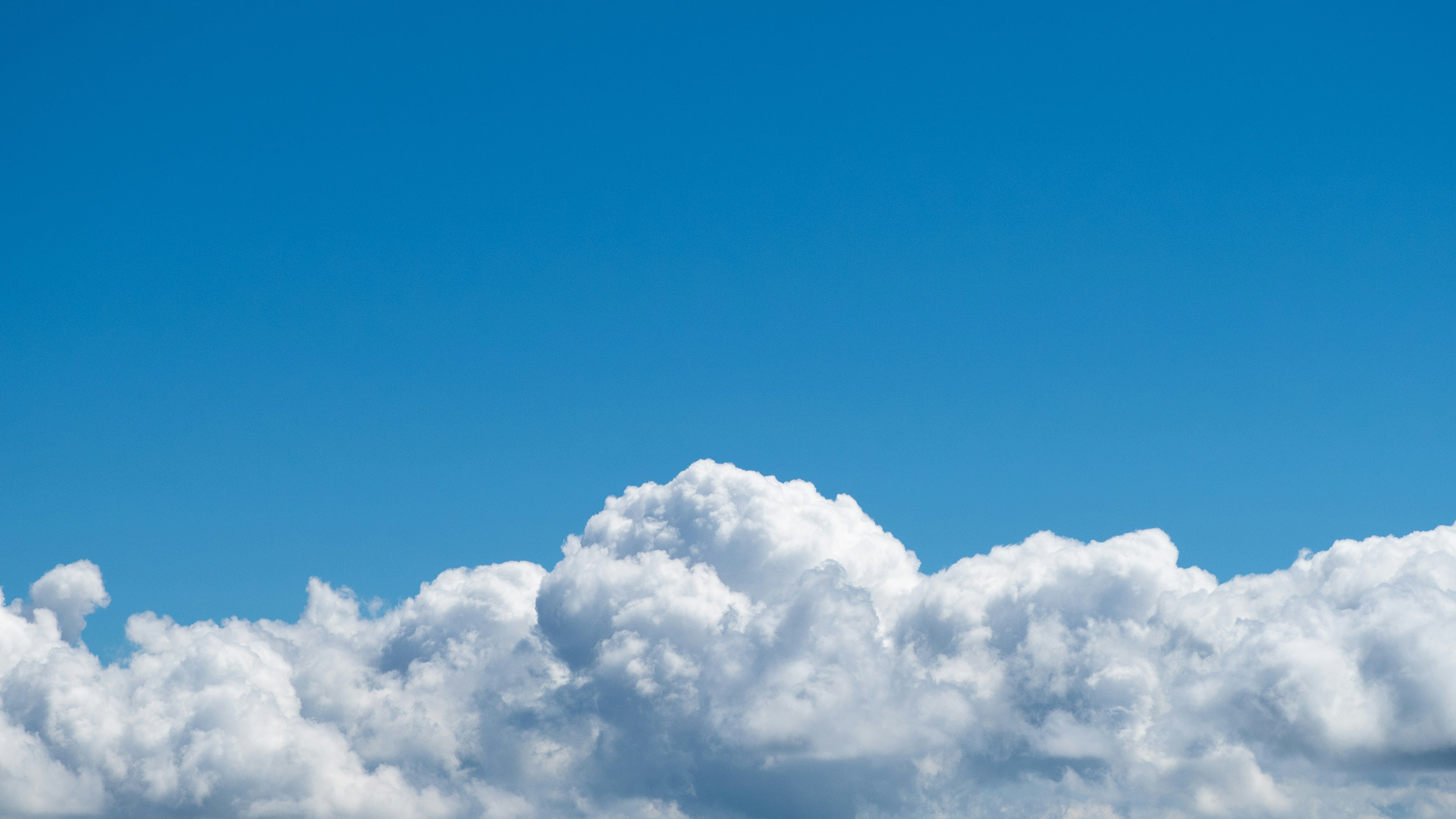 Blue sky with fluffy white clouds.