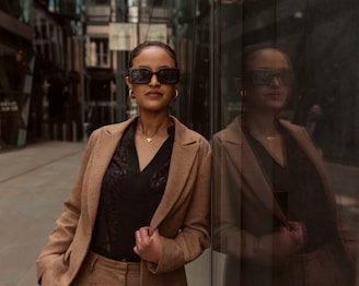Stylish woman poses next to a reflective wall.
