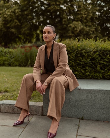 A stylish woman poses outdoors in a suit.