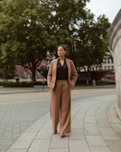 Woman in a suit walks down a city street.