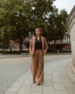 Woman in a suit walks down a city street.
