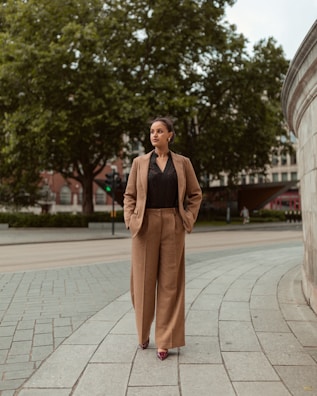 Woman in a suit walks down a city street.